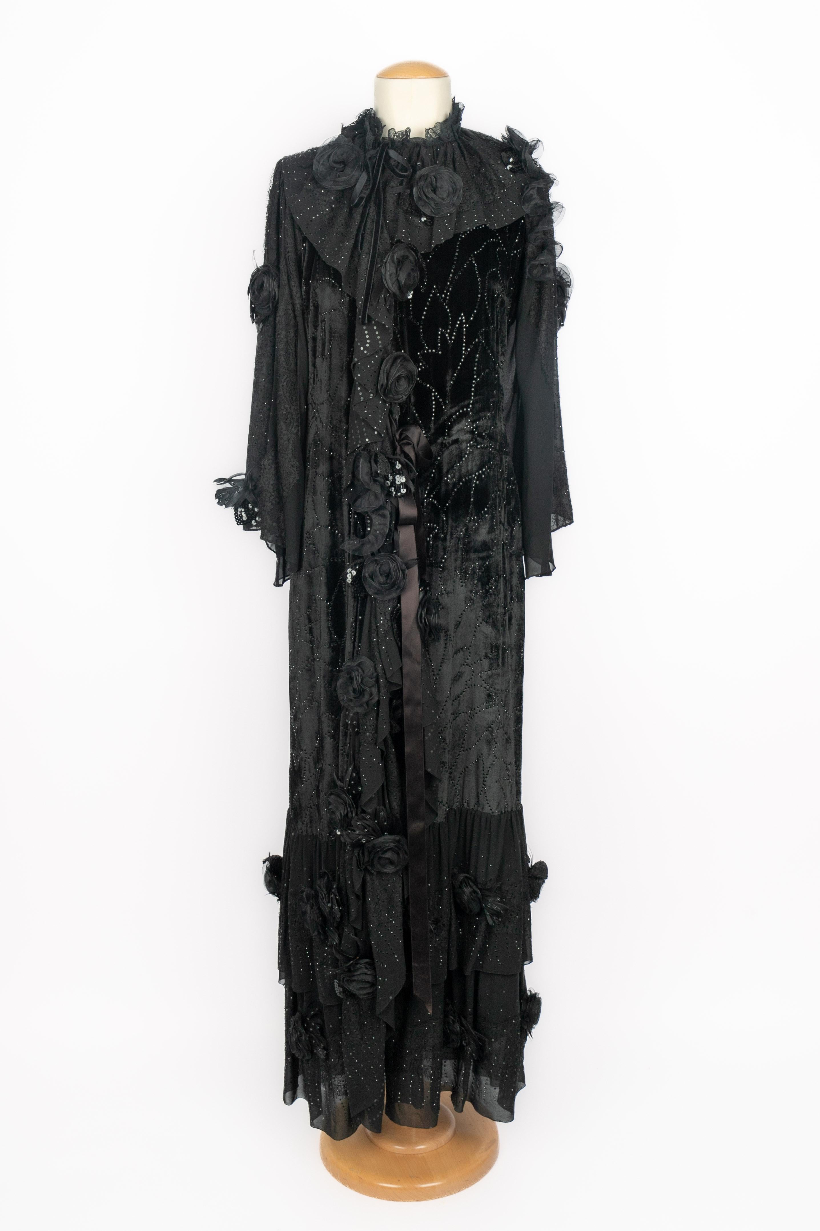 UNGARO - (Made in France) Black muslin and velvet panne evening coat. Relief flower and rhinestone decorations. Asymmetrical knotted fastener. Wide long sleeves. Composition and size labels missing, it fits a 36FR/38FR. 1980 Fall-Winter Haute