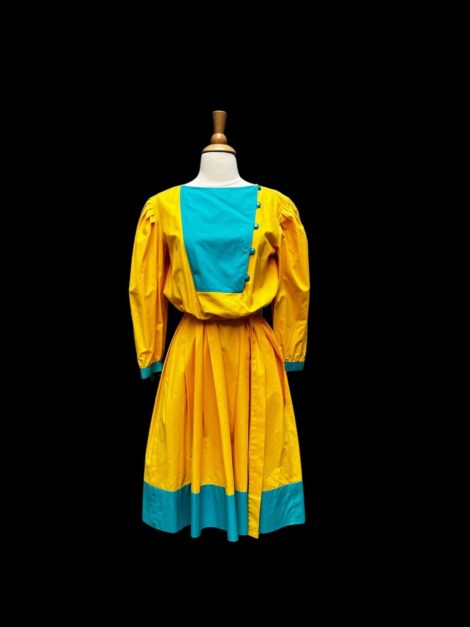 Emanuel Ungaro yellow & turquoise blue cotton dress. blouson bodice, fitted waist and full skirt with hip pockets. bracelet sleeves. 6 buttons at the side of the bodice, can be worn open or closed. dress has a side zip closure. self fabric belt and
