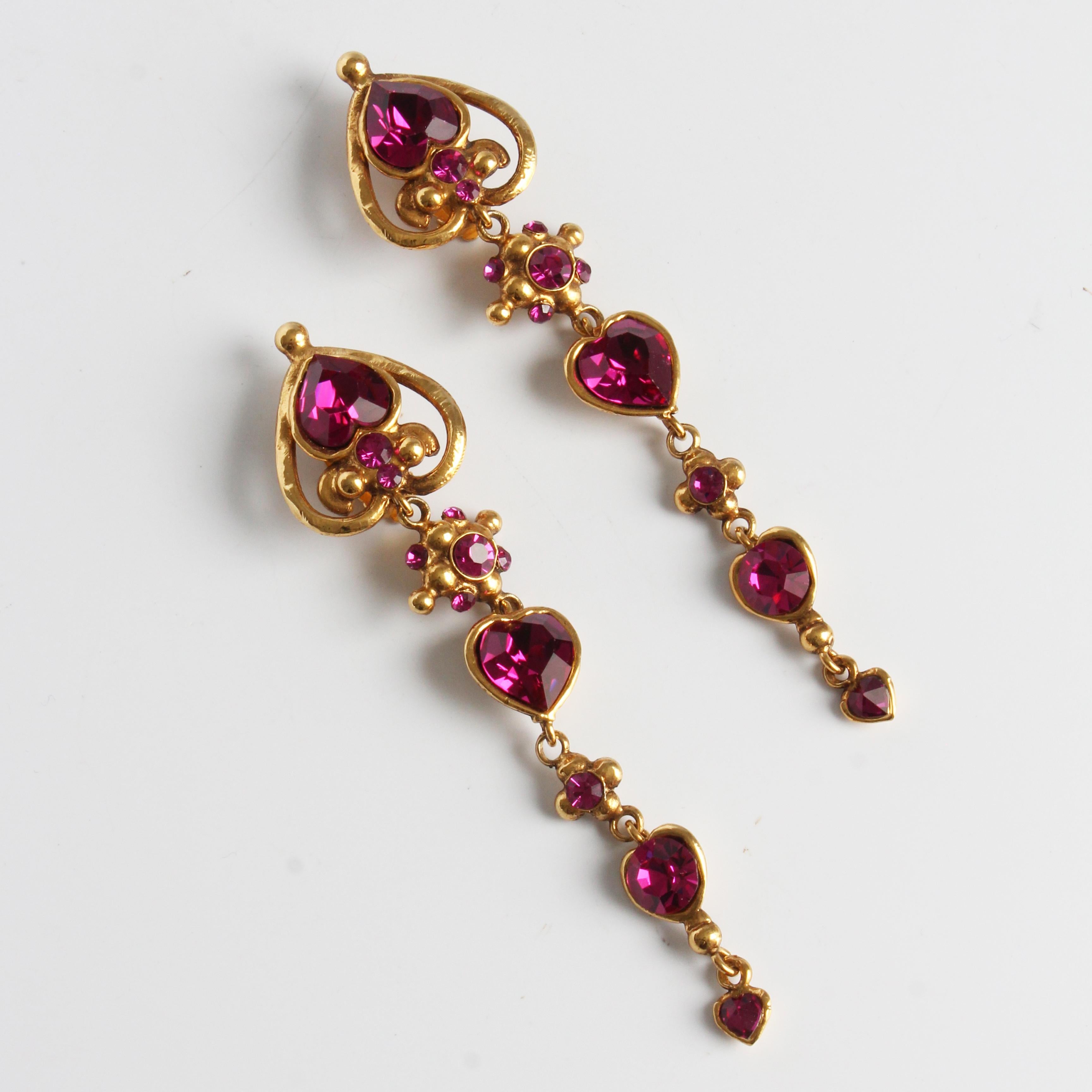 Authentic, preowned, vintage long dangle earrings, made by Emanuel Ungaro Paris, most likely in the 80s.  Made from gold metal, these baroque style earrings are set with deep pink stones which twinkle in certain light!   

A gorgeous set of