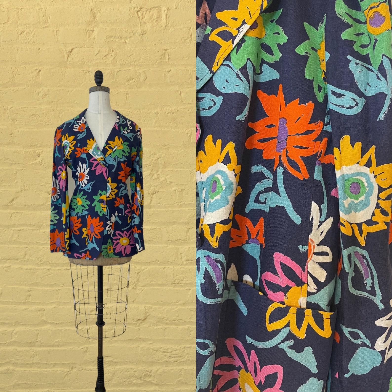 Blazer Vintage Ungaro. bleu marine avec un imprimé de fleurs colorées à grande échelle. revers cranté. poches plaquées. fermeture à bouton unique. la veste n'est pas doublée.

✩ Il s'agit d'une pièce étonnante de l'histoire de la mode réalisée par
