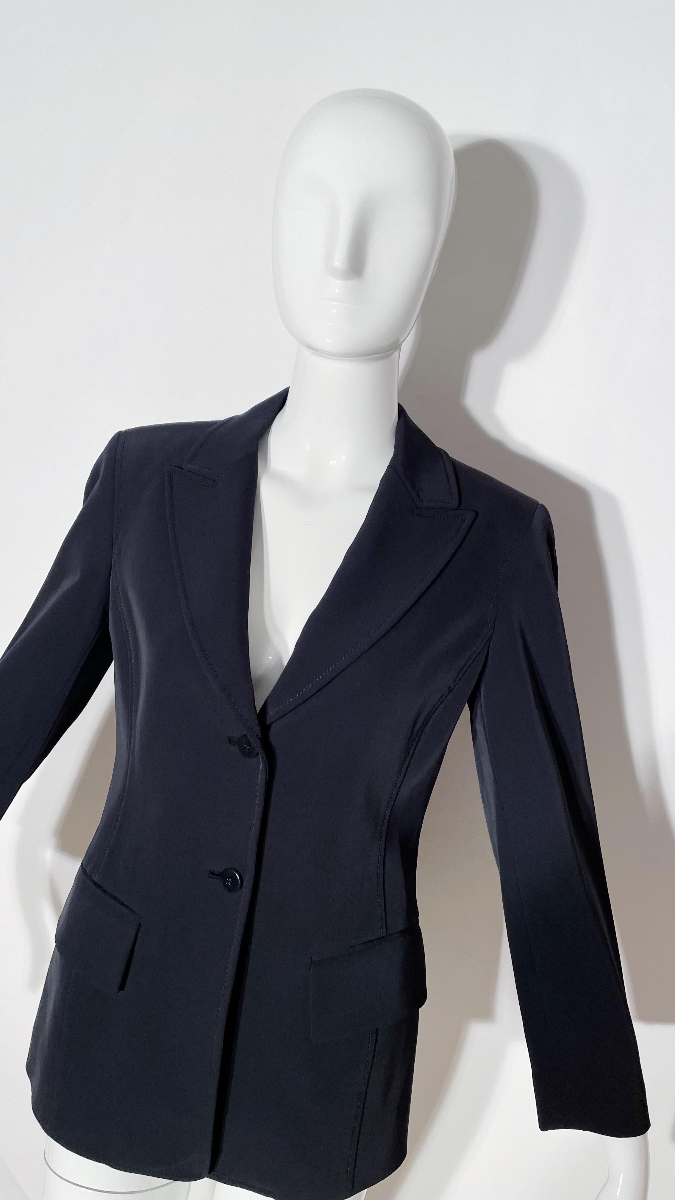 Black neoprene blazer. Lapel. Front button closure. Front pockets. Lined. Nylon. Made in China. 
*Condition: excellent vintage condition. No visible flaws.
Measurements Taken Laying Flat (inches)—
Shoulder to Shoulder:16 in.
Sleeve Length: 22