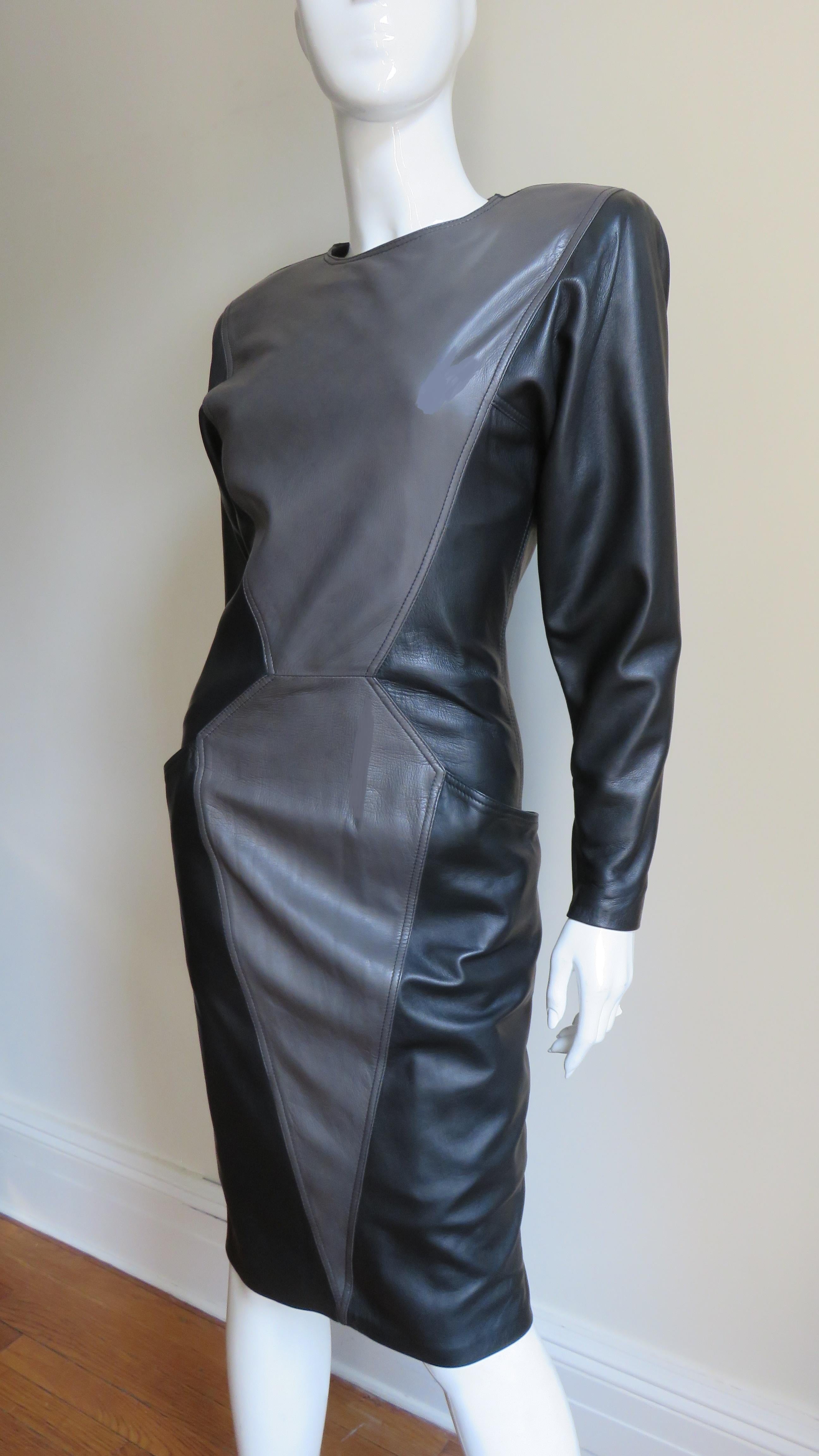 A fabulous soft, supple leather dress by Emanuel Ungaro in black and grey.  It has a crew neckline, long sleeves with zipper cuffs and shoulder pads. The dress is black with an angular grey center front panel on the bodice and skirt flatteringly