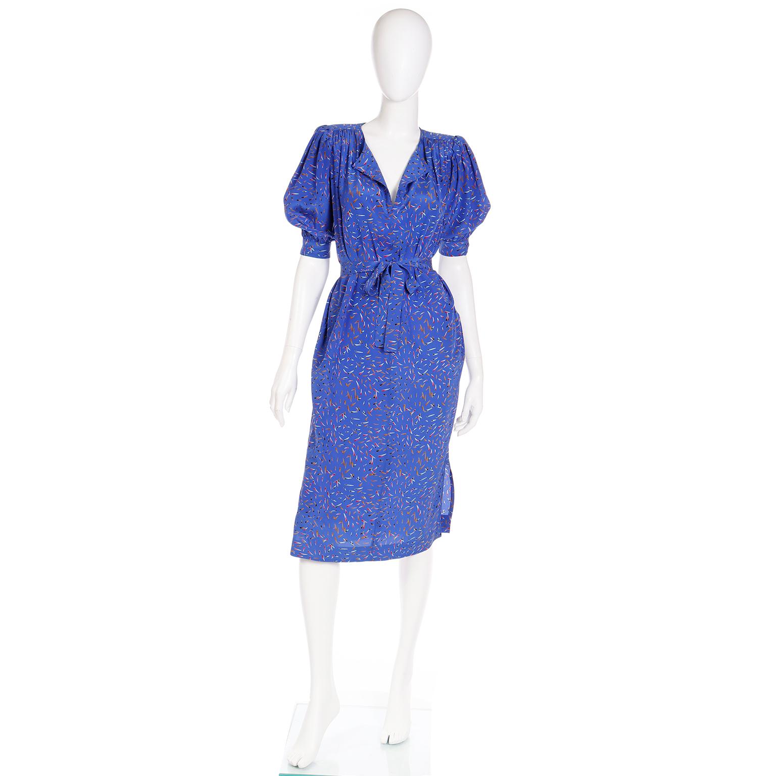 This vintage blue silk vintage Ungaro Parallele dress comes with a fabric sash and is in excellent condition. The print resembles multi colored tiny feathers or arrows.The dress has pretty gathering at the shoulders, side slit pockets, shoulder