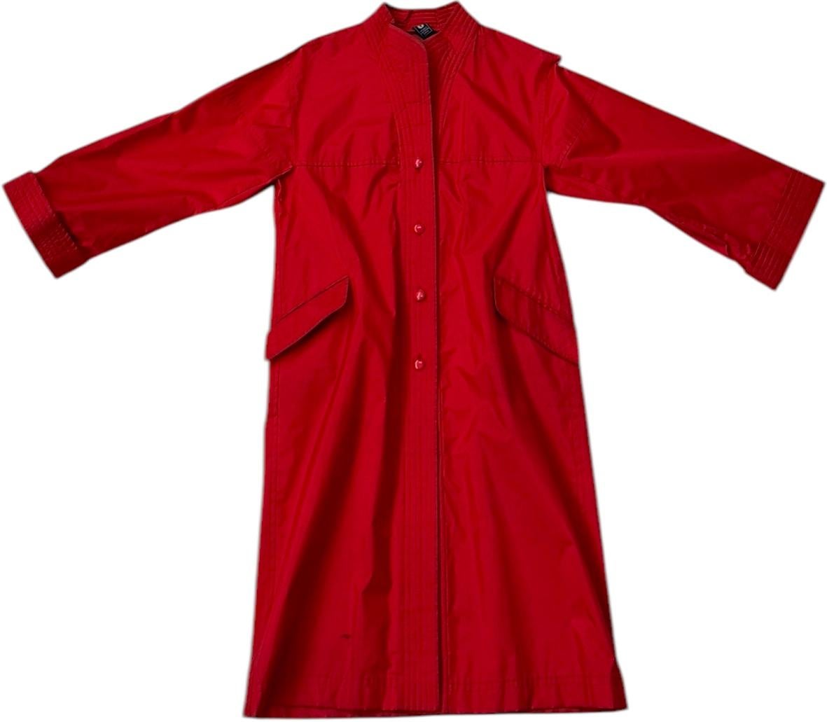 Bold, architectural, and effortlessly elegant, this vintage Emanuel Ungaro Parallèle duster coat from the late 1980s is a striking example of refined utility in French ready-to-wear design.

Rendered in a vibrant red fabric-likely a structured
