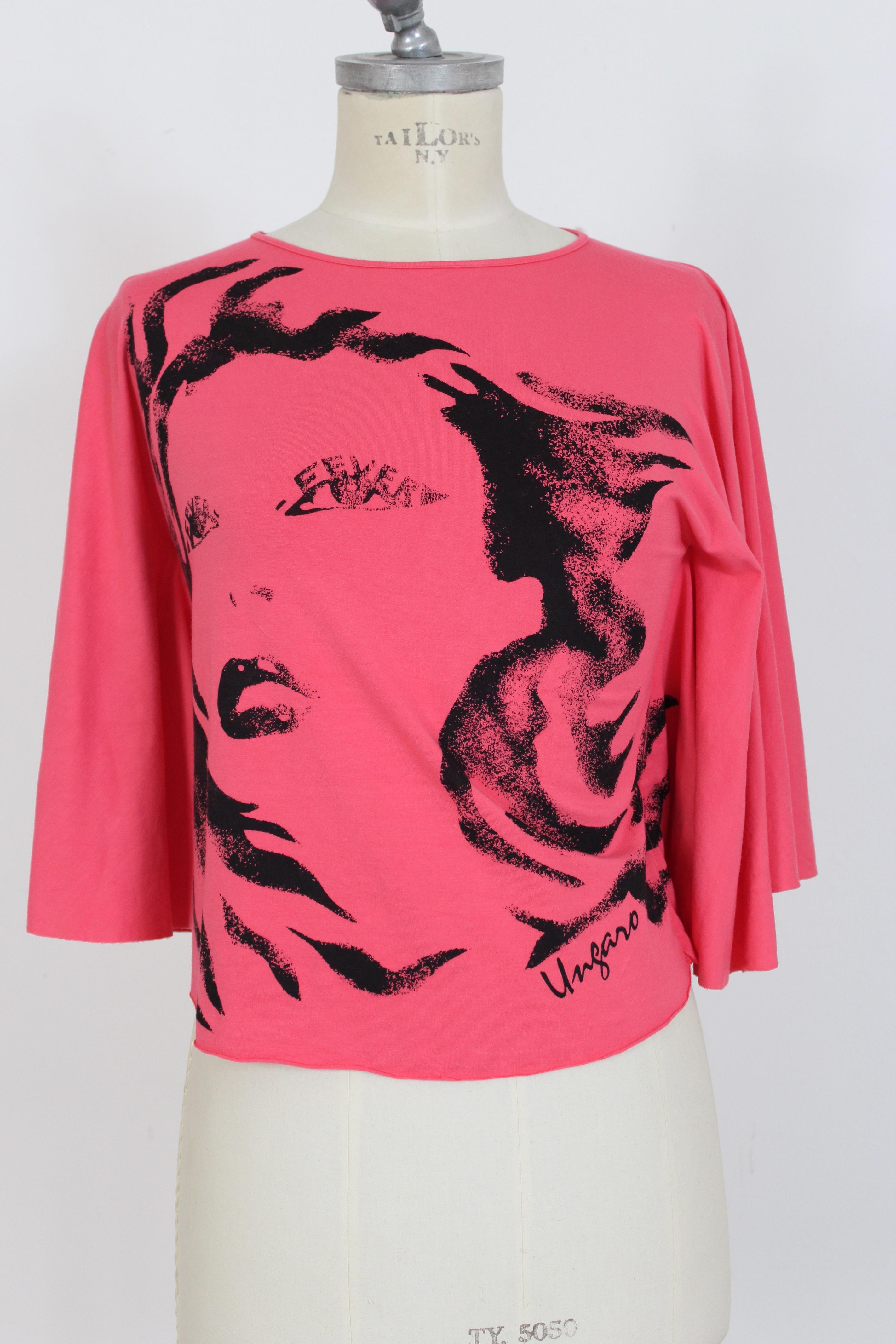 Emanuel Ungaro 90s vintage women's shirt. Short shirt with wide batwing sleeves. Pink color with black woman face print. Stretch cotton fabric. Made in Italy.

Condition: Excellent

Item used few times, it remains in its excellent condition. There