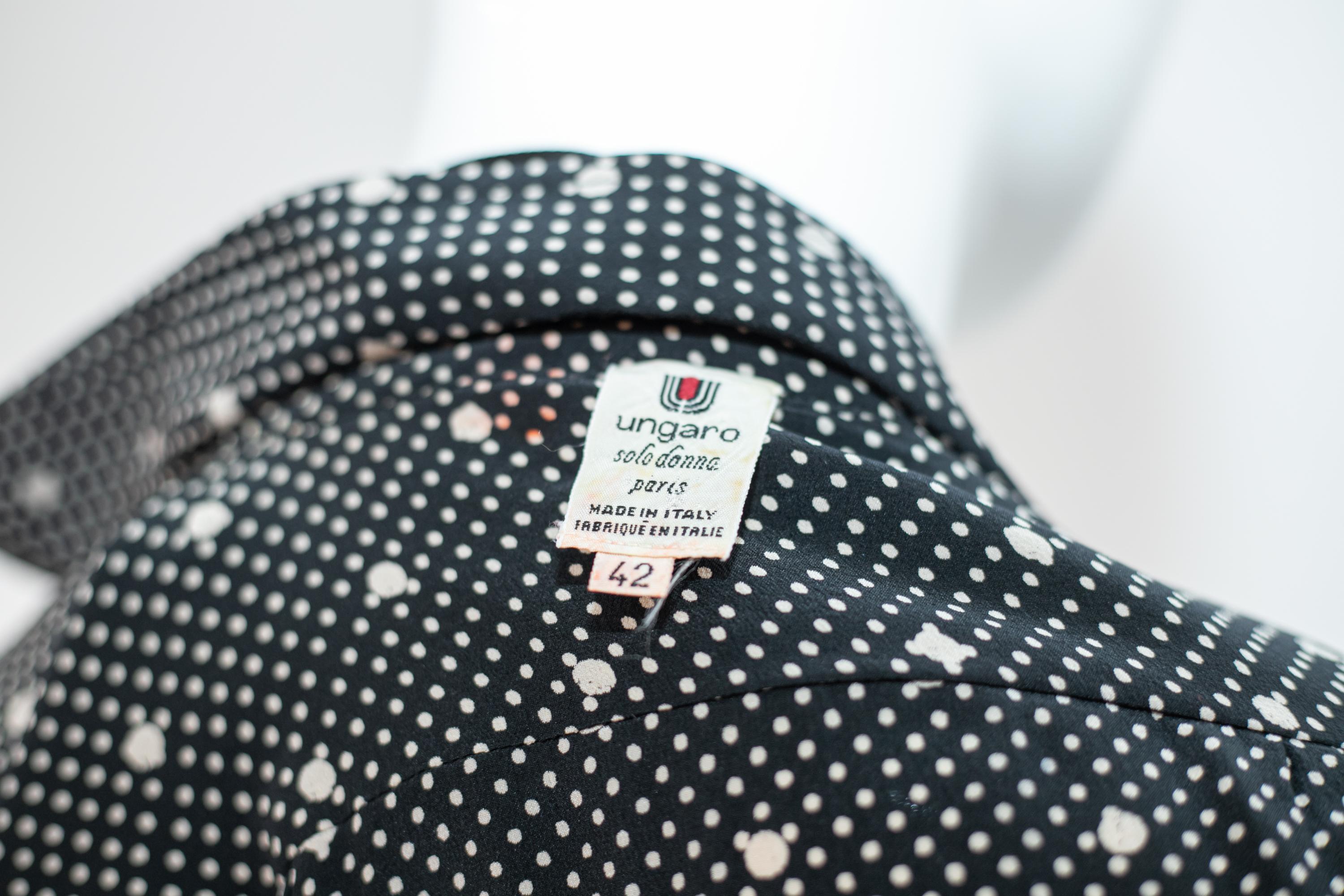 Charming polka dot blouse designed by Emanuel Ungaro in the 1990s, made in Italy.
The shirt has two main colors, black and white. It has long, soft sleeves with narrower cuffs, which create a very charming and sweet effect. The collar is high and