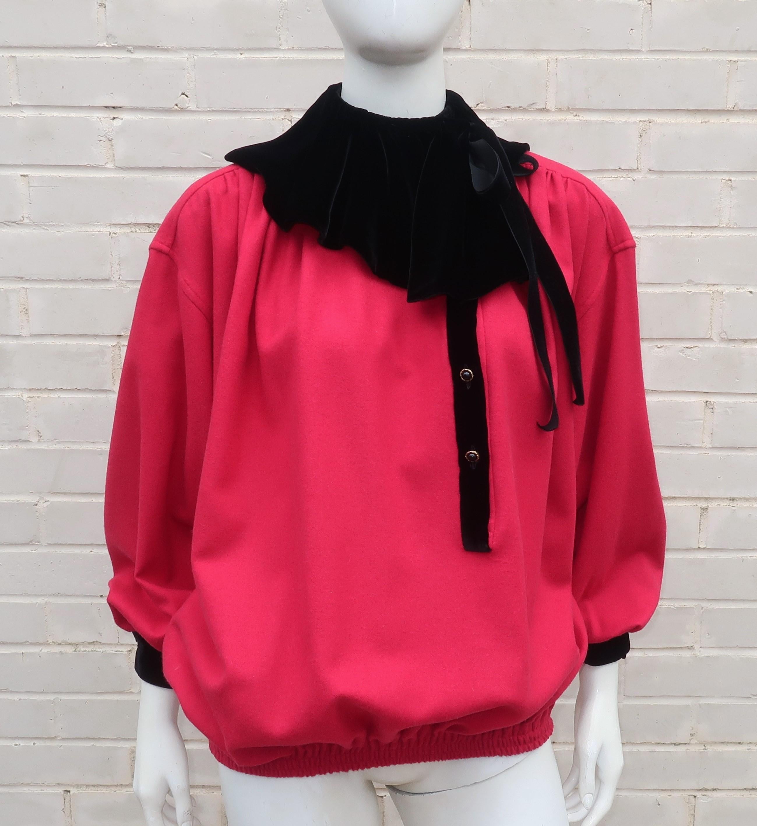 An adorable Emanuel Ungaro red wool pullover top with black velvet ruffled collar, necktie and cuffs.  It partially buttons down the front with hidden side pockets and has an elasticized waistband that helps create a full silhouette akin to a