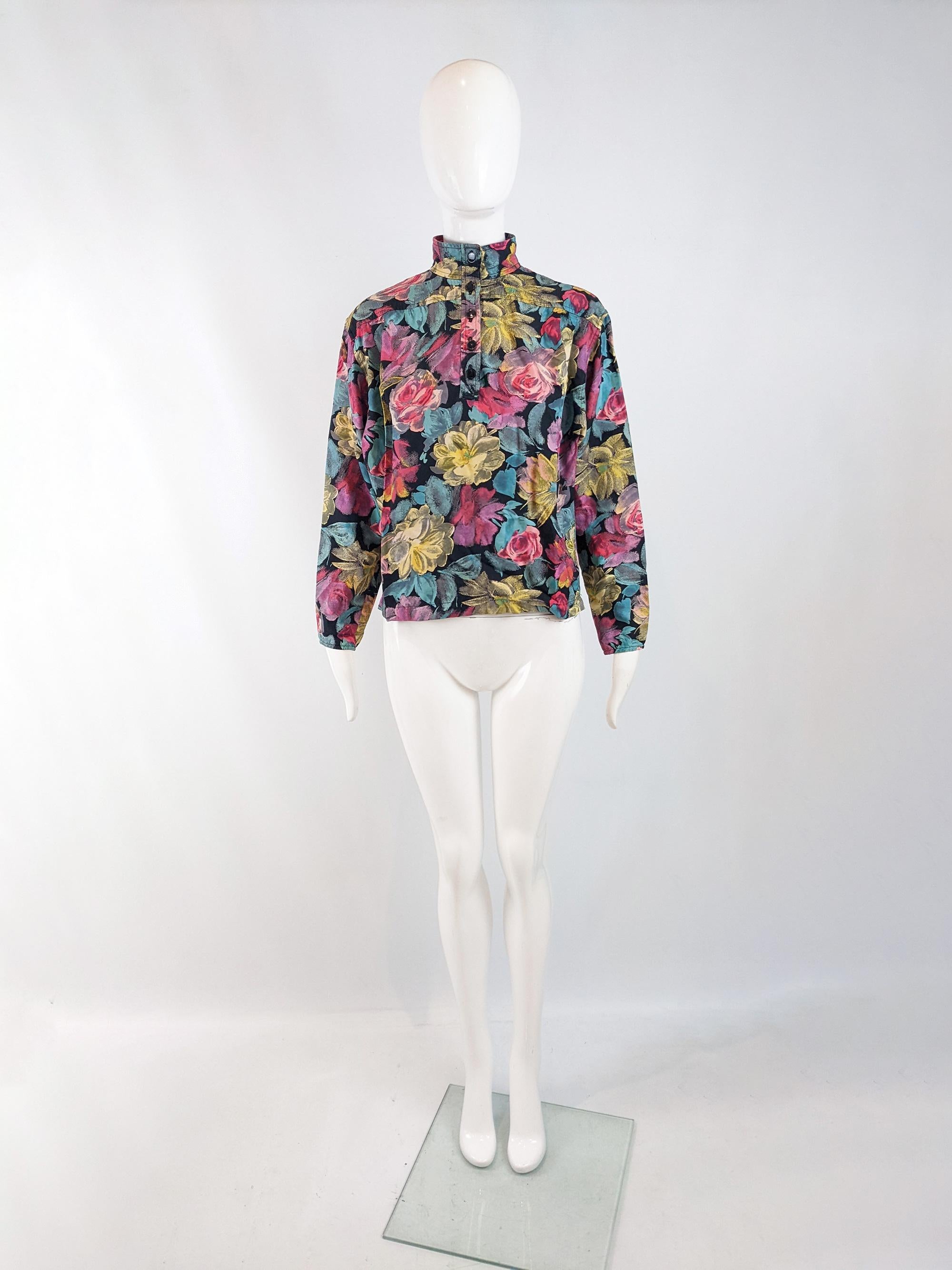A bold vintage womens blouse from the 80s by luxury fashion designer, Emanuel Ungaro. In a black rayon with a vibrant, multicoloured floral print throughout. It has a batwing sleeve and a glamorous high neck.

Size: Marked vintage US 8 which equates