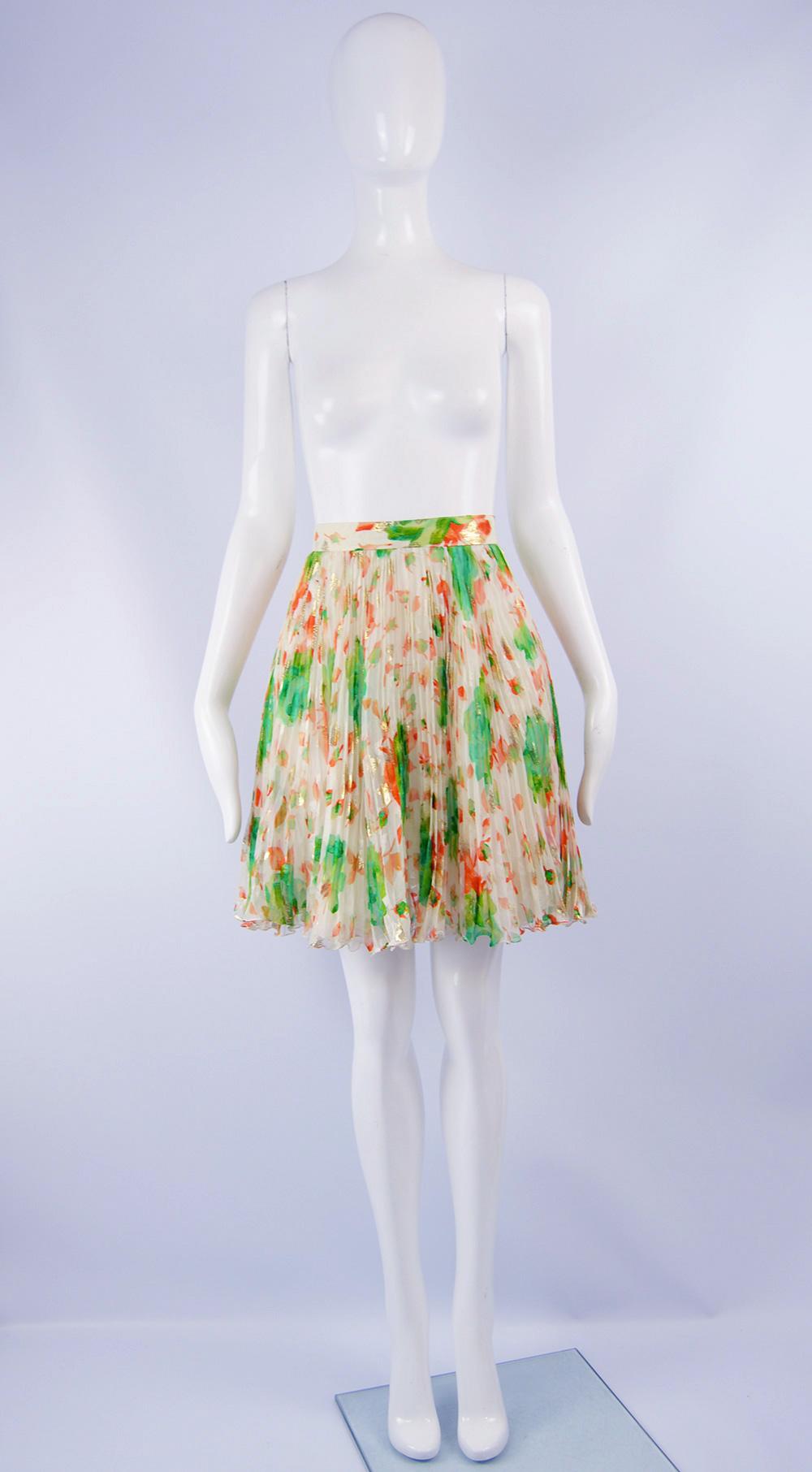 A fabulous vintage mini skirt from the 80s by luxury French fashion designer, Emanuel Ungaro. In a floaty, off white silk chiffon (please note color of the skirt is slightly whiter than in the pictures) with a bold orange and green print and satin
