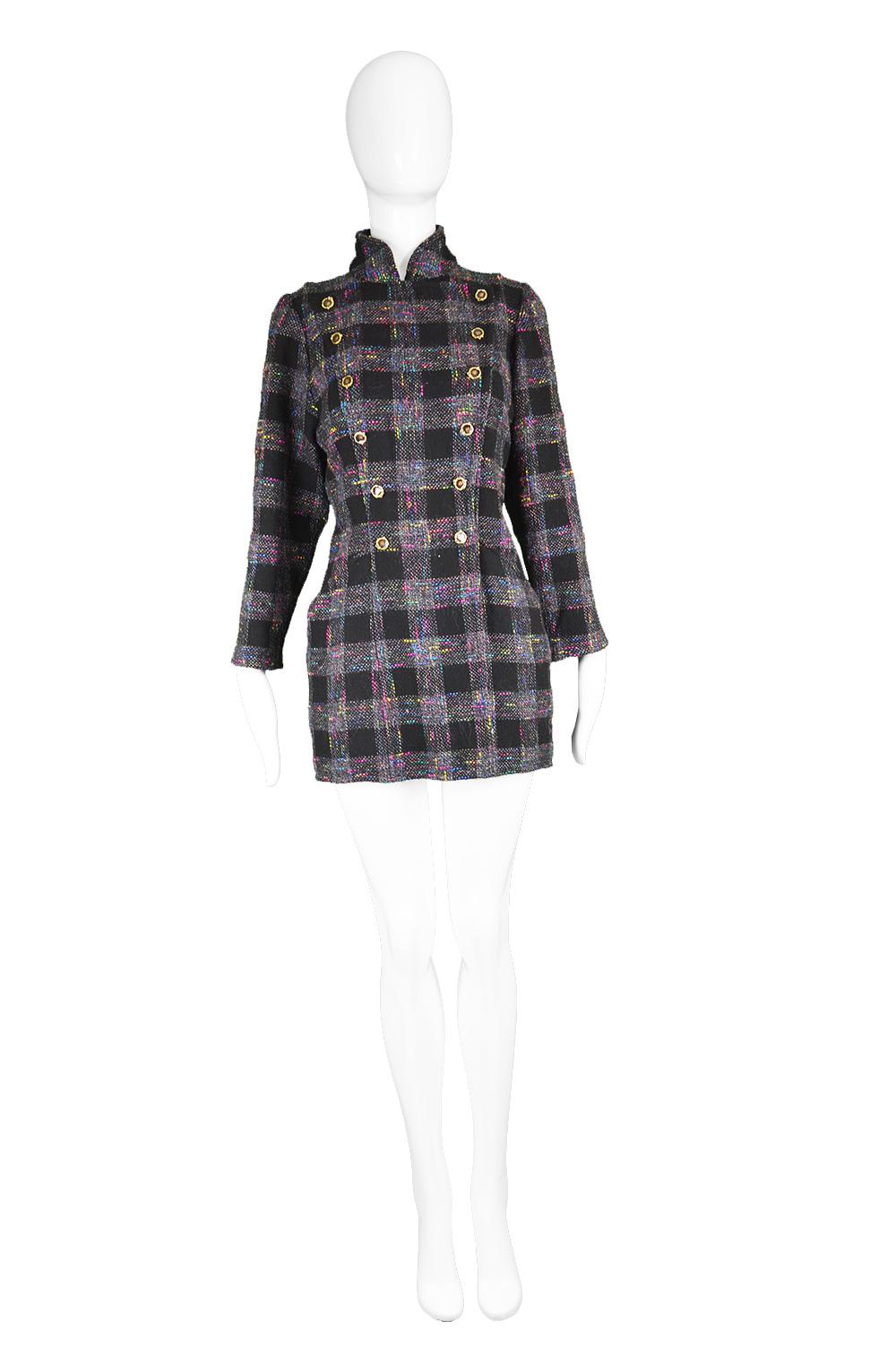 A chic vintage women's jacket from the 80s by luxury Italian fashion designer, Emanuel Ungaro. In a black wool boucle tweed with a plaid check pattern and multicolored flecks throughout. With a high collar and ornate double breasted buttons that