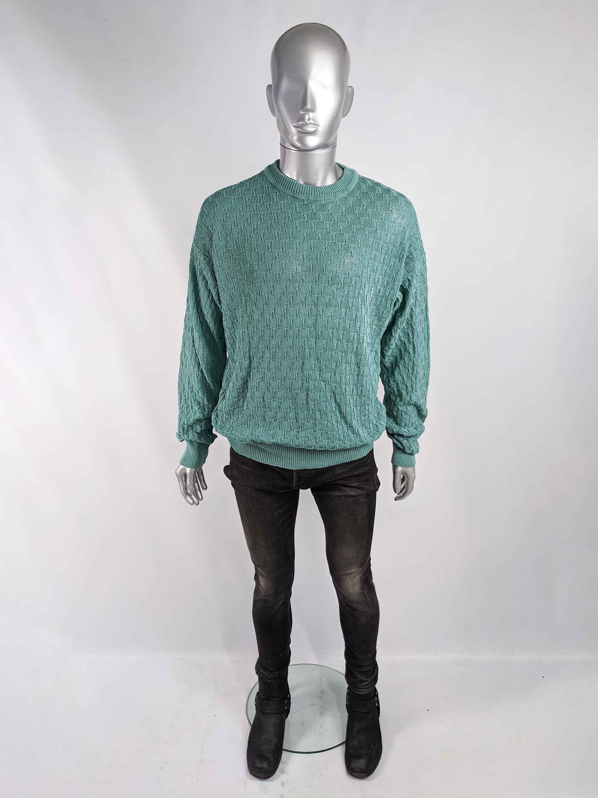 A stylish vintage mens Emanuel Ungaro jumper from the 80s. In an unusual, twisted style, turquoise mercerised cotton knit fabric with a ribbed crew neck and hem. 

Size: Marked L but this gives a loose, relaxed fit. 
Chest - 48” / 122cm
Waist - 42”