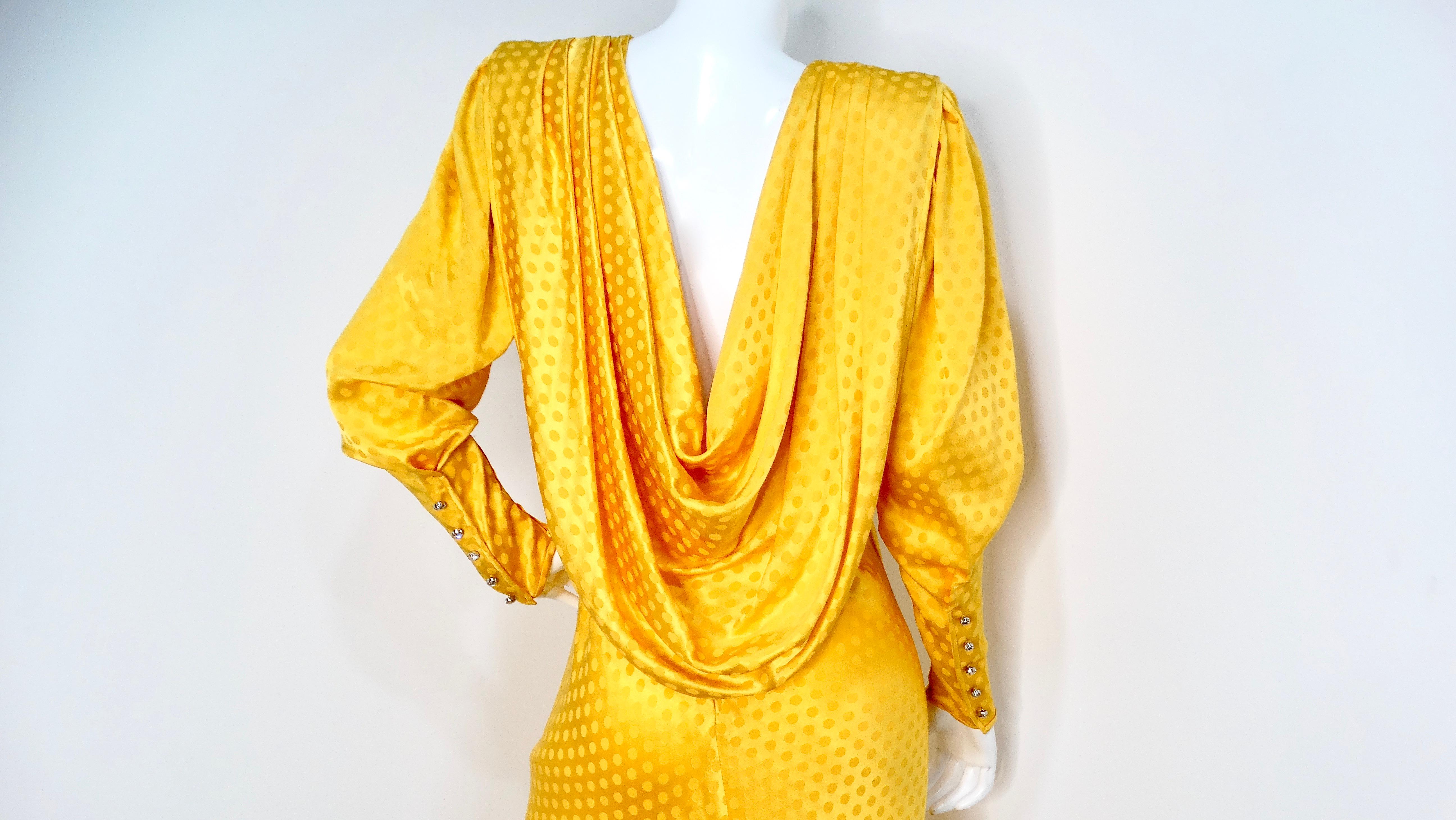 Step into a world of vintage elegance with the Emanuel Ungaro Vintage 1970s Yellow Polka-Dot Draped Silk Gown. This stunning piece features long sleeves that taper elegantly at the wrists, adorned with crystal faux buttons while securing with a