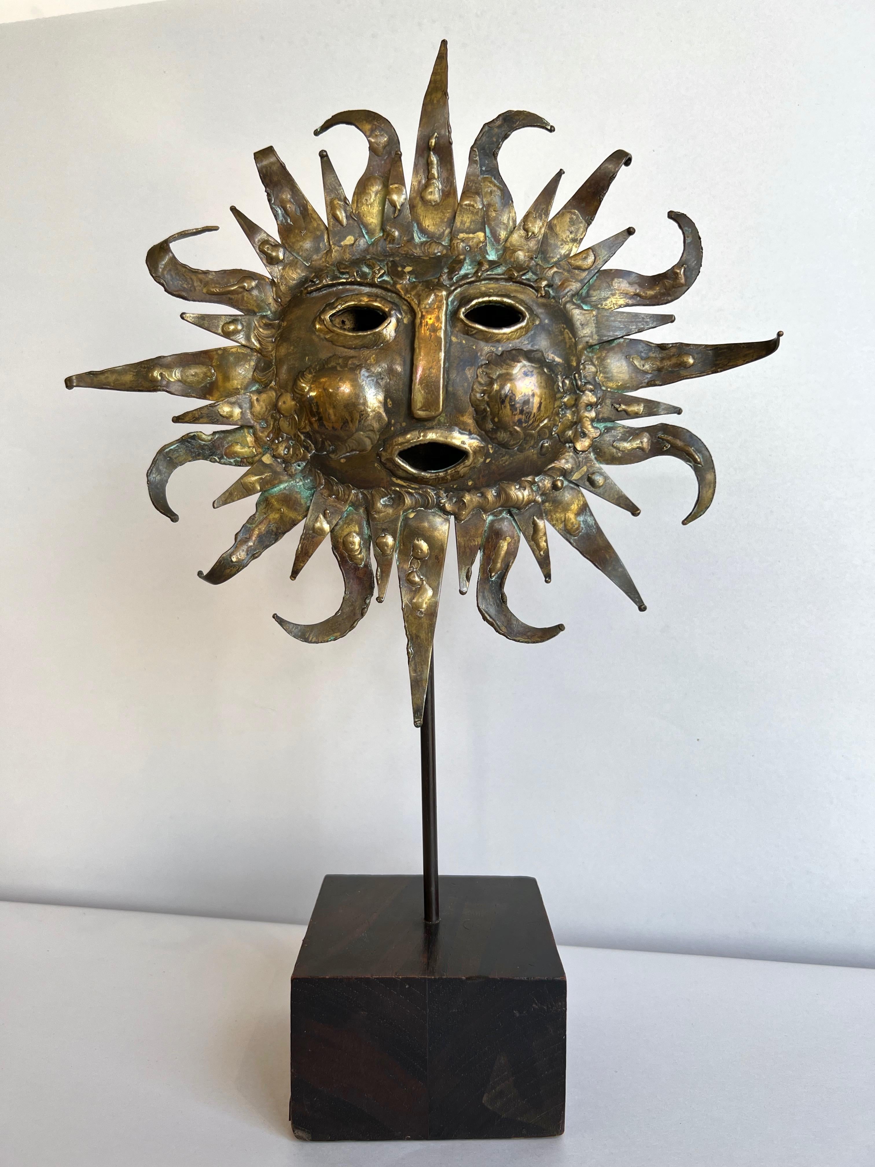 An enchanting 1960s Brutalist brass and bronze sun face sculpture on wood stand handcrafted by the Benedictine monks of Emaús, their workshop in Santa María Ahuacatitlán, Mexico.

A variety of brass and bronze Brutalist metalworking techniques are