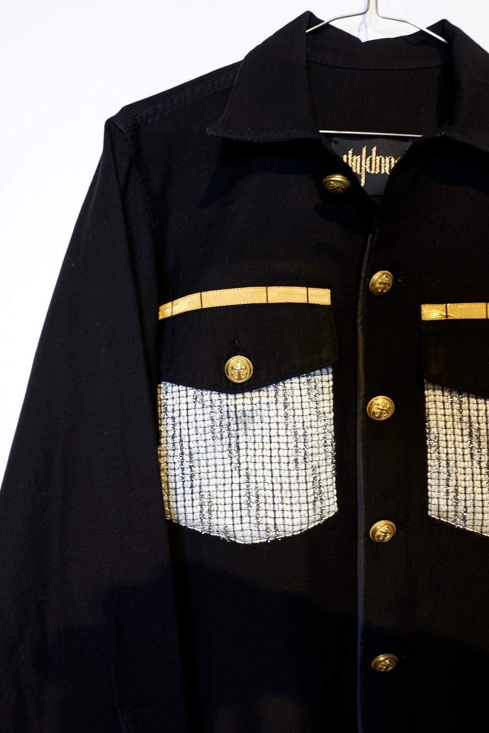 Embellished Repurposed Original Us Military Fatigue Shirt Dyed Black from the 70's in 100% Cotton. Embellished with Vintage Designer Lurex Tweed from France, Gold tone Brass Buttons, Details of Black Silk and Military Gold Braids.

Brand: J