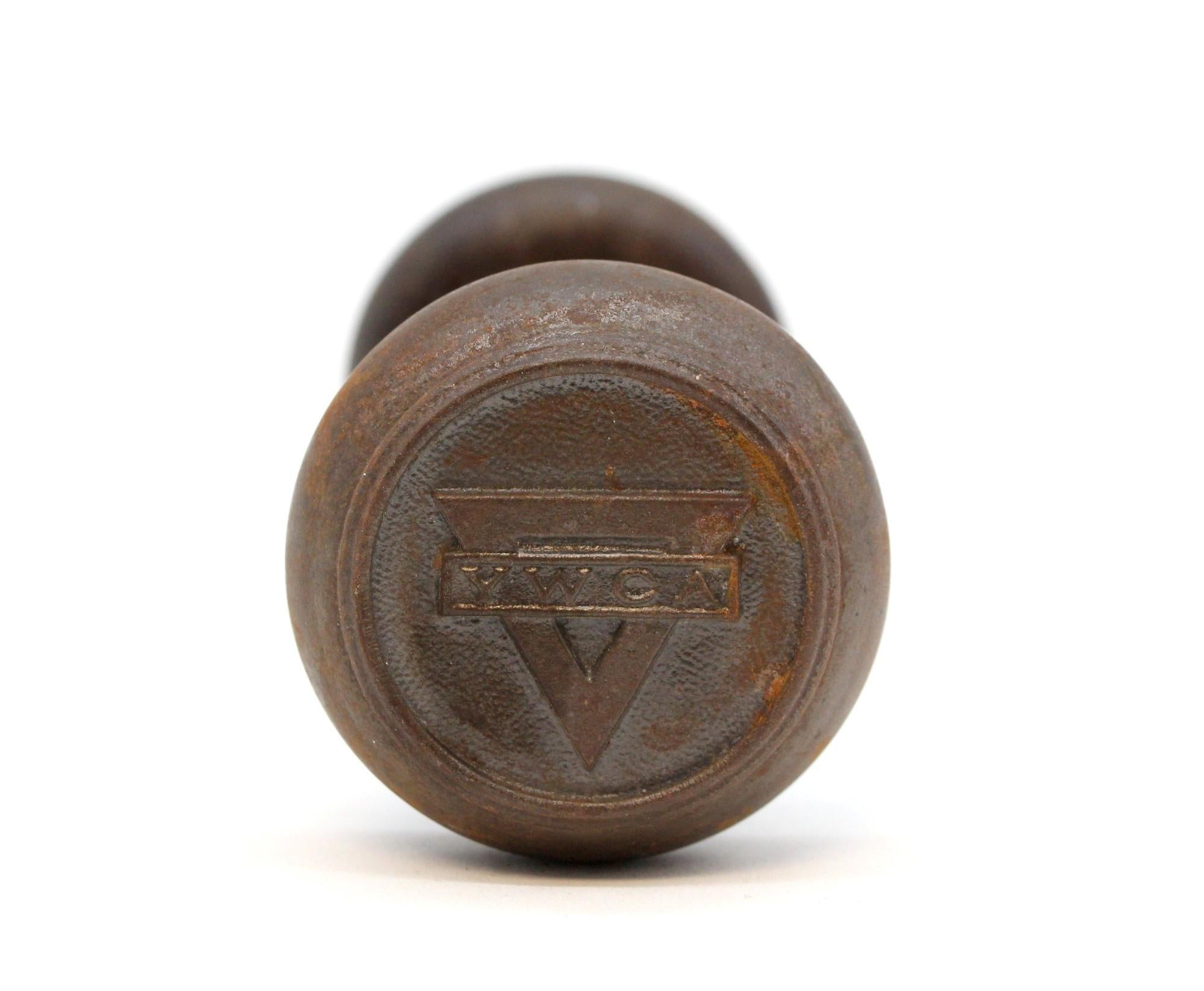 Bouton de porte emblématique en fonte avec les initiales YMCA sur les deux extrémités. Parmi les collectionneurs, il est connu comme faisant partie du groupe P-80460 YWCA. L'ensemble comprend deux boutons avec une broche 
