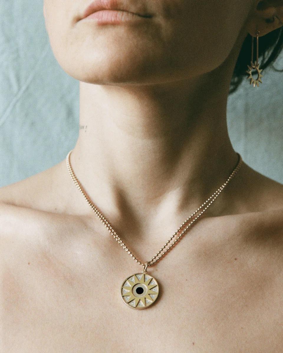 The Star Pendant – designed and handmade by EMBLM Fine Jewelry

This circular pendant is cast in solid gold, with a sandblast finish beneath the twelve point star design. The external elements of the pendant are then high polished, creating a