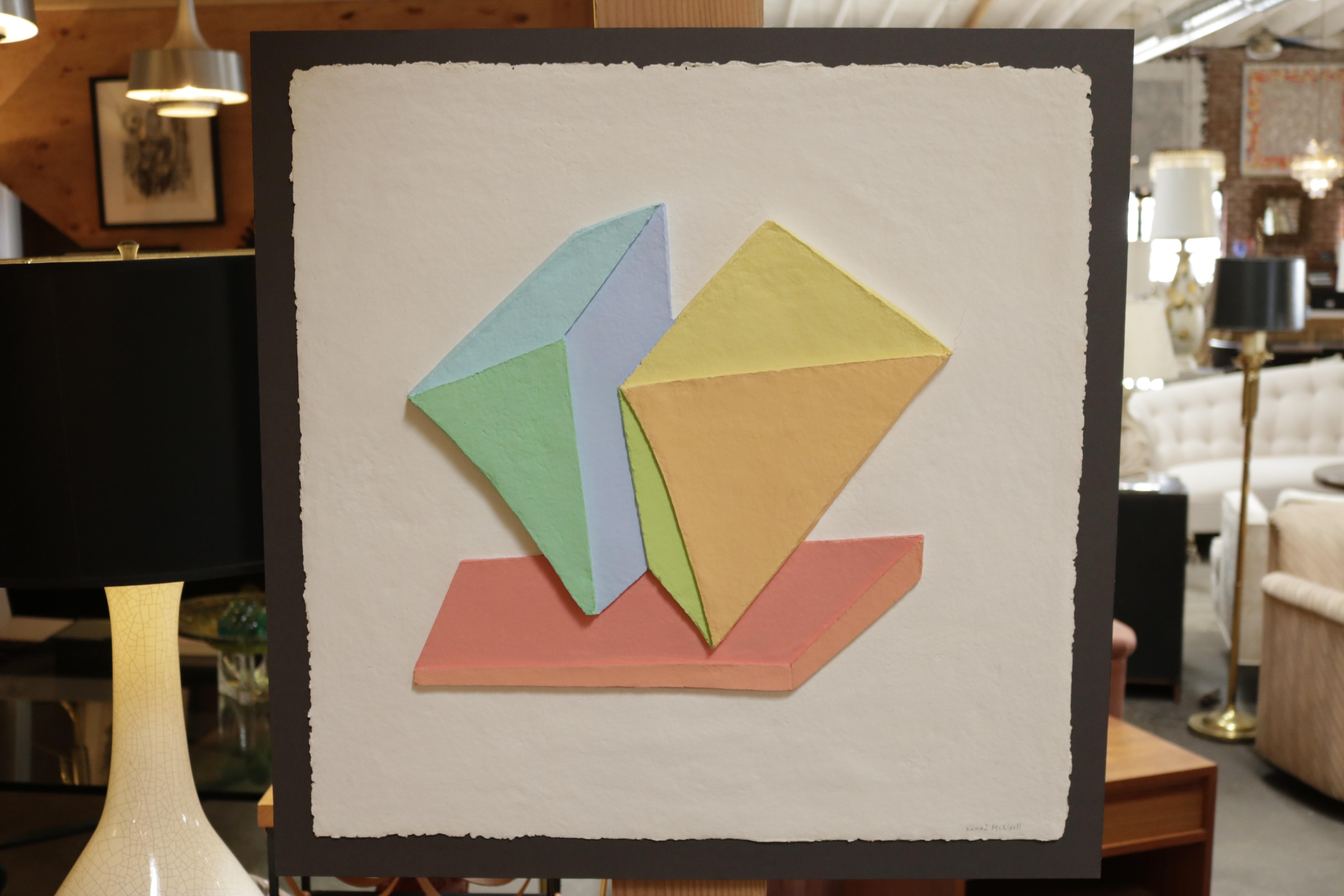 Geometric 3D collage painting by Ricki McNeill made with stacking paper sheets, gluing them together and dipping them in pastel watercolor then creating geometric shapes The art is enclosed in a Lucite box.

Ms. McNeill was a resident of Santa