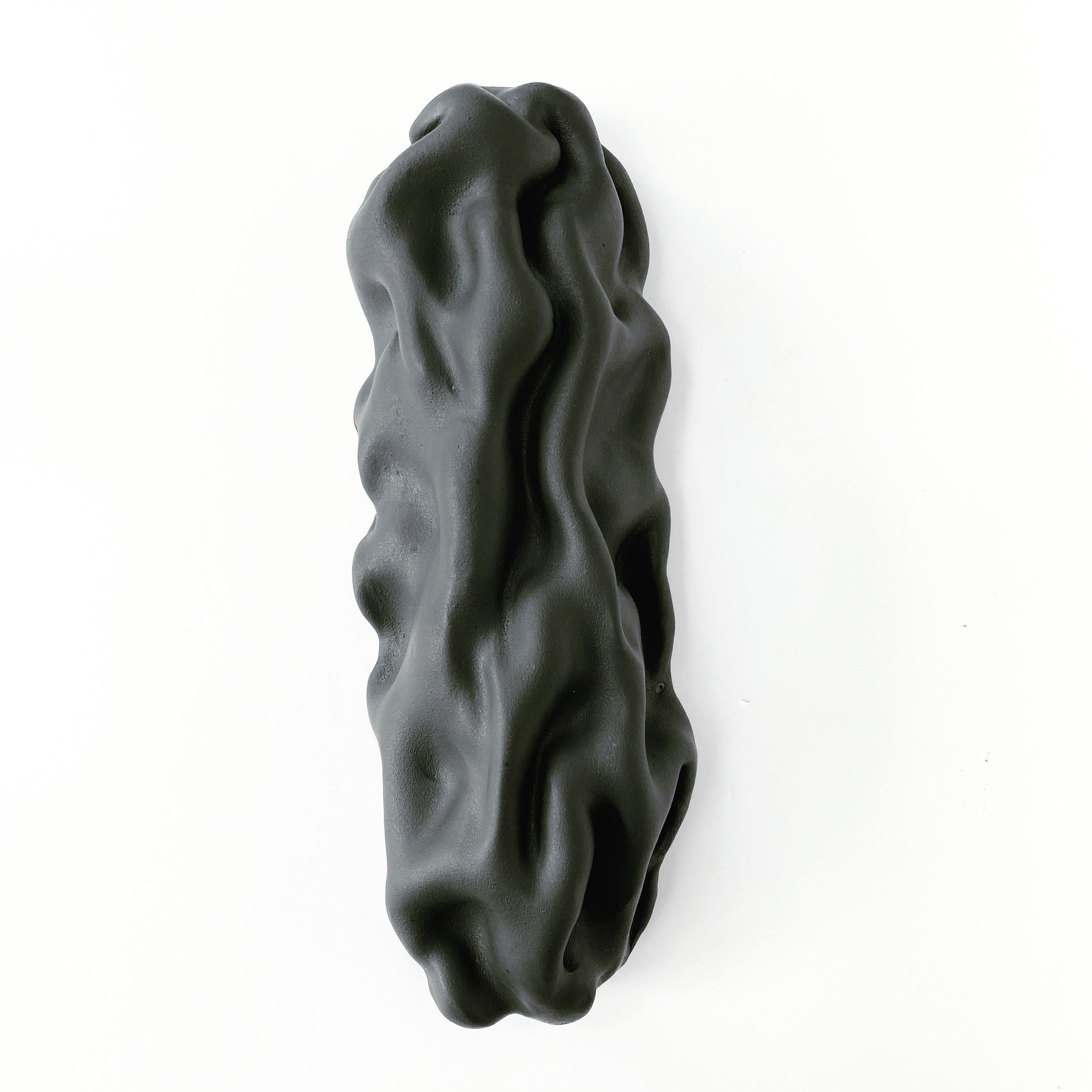 Emboss wall sculpture II by Sophie Rogers
Dimensions: D 8 x W 12 x H 32 cm
Materials: Ceramic, glaze
Other glaze colors available.

Wall sculpture with undulating shape like a draped piece of cloth. Changes expression depending on the light
