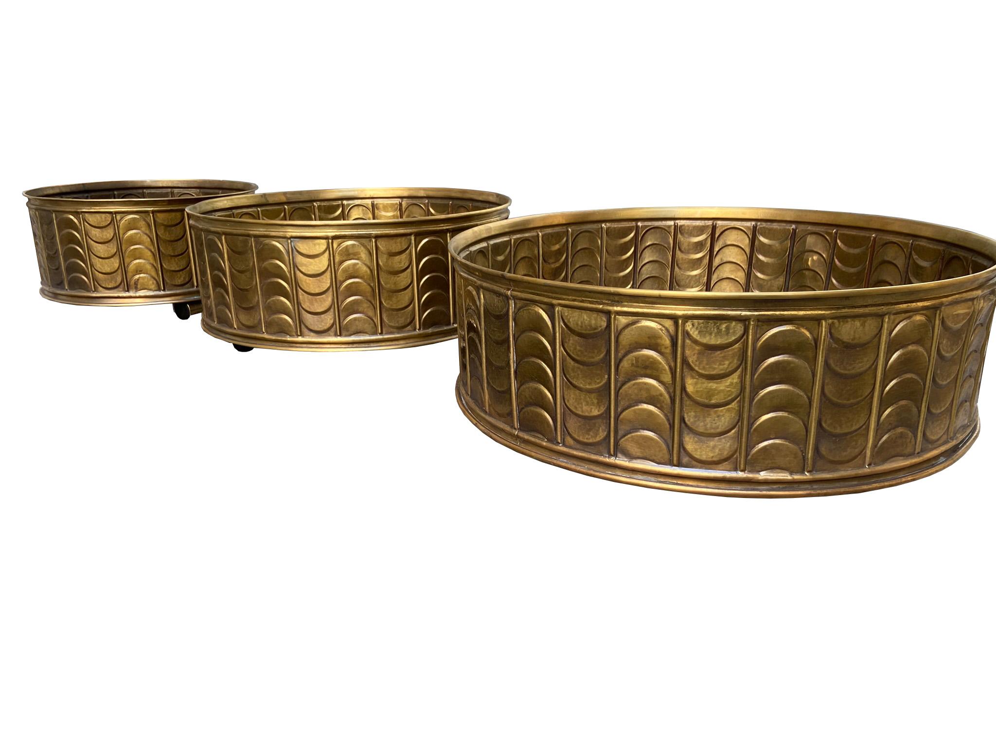 Group of 3 magnificent cachepot in embossed brass with wheels, of various sizes, storable one in the other.