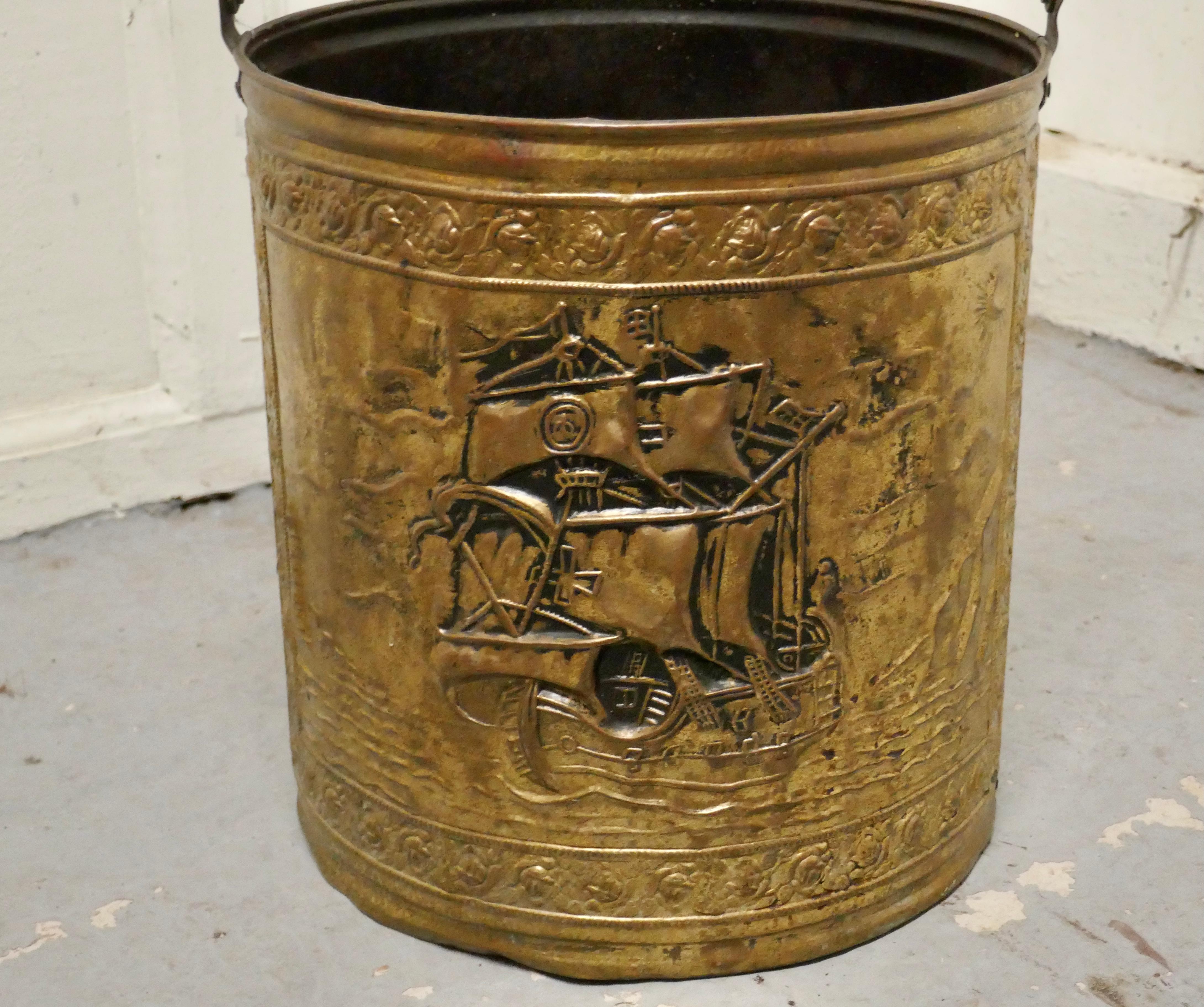 Embossed Brass coal bucket with a tea clipper sea scene 

This bucket is an attractive round shape, it is made in pressed brass and has a swing handle

The bucket is in good used condition, and is ready to go to work and grace your fireside at