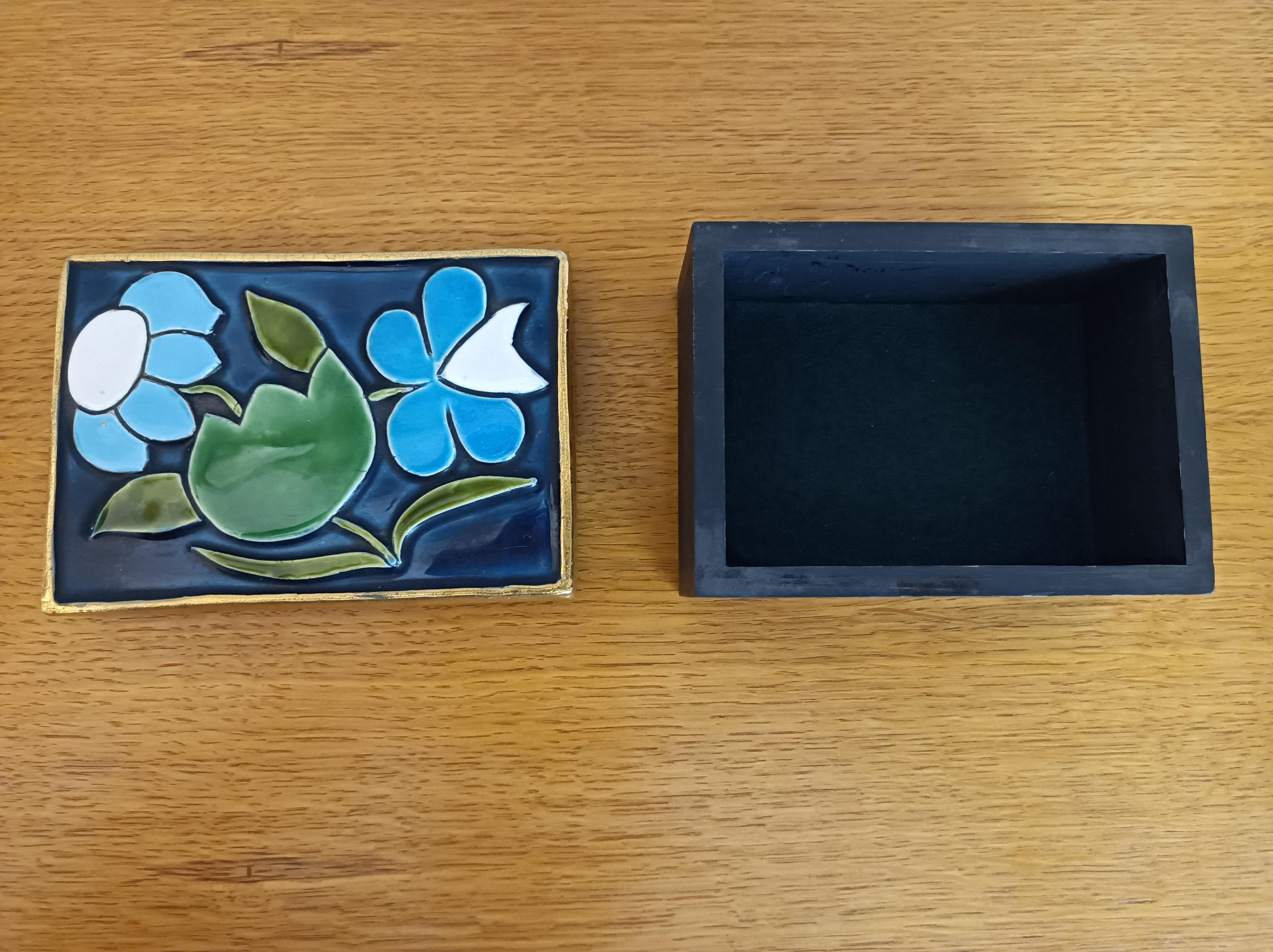 Un coffre rectangulaire avec trois fleurs émaillées en vert, bleu et blanc.
Cadre doré craquelé.
Base en bois avec feutre vert à l'arrière.
France,
Circa 1970

Dimensions : 
Hauteur ( max) : 6 cm / 2,36 inch 
Longueur : 10,5 cm / 14,13 inch