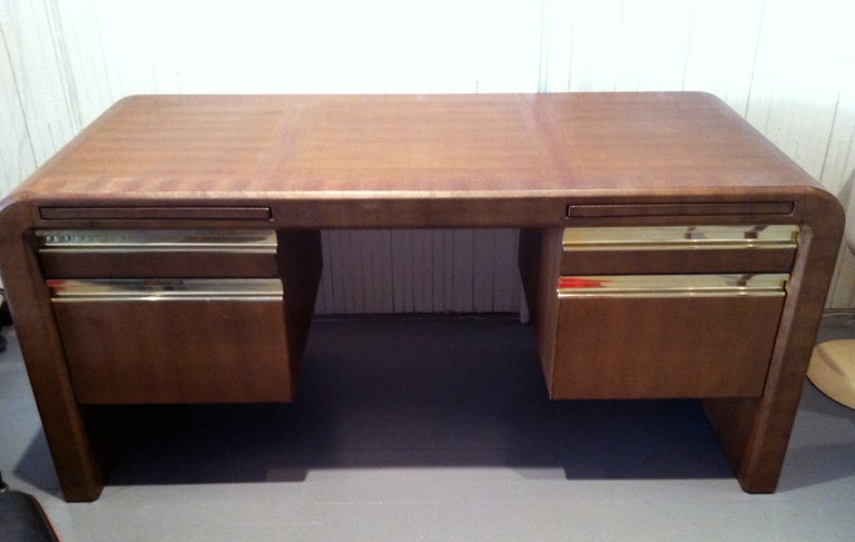 A substantial leather-clad desk designed by Karl Springer, circa 1982. Heavy wood construction completely encased in pattern embossed leather on all sides. The desk features two rows of drawers on either side with anodized aluminum handles, as well