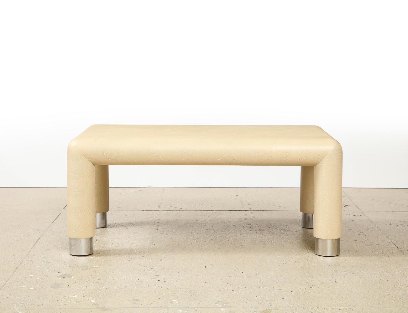 Wood, embossed leather and chromed metal. 2 cocktail tables of cream-colored leather, embossed with lizard pattern & chromed metal feet. Label affixed to the bottom of each table.
