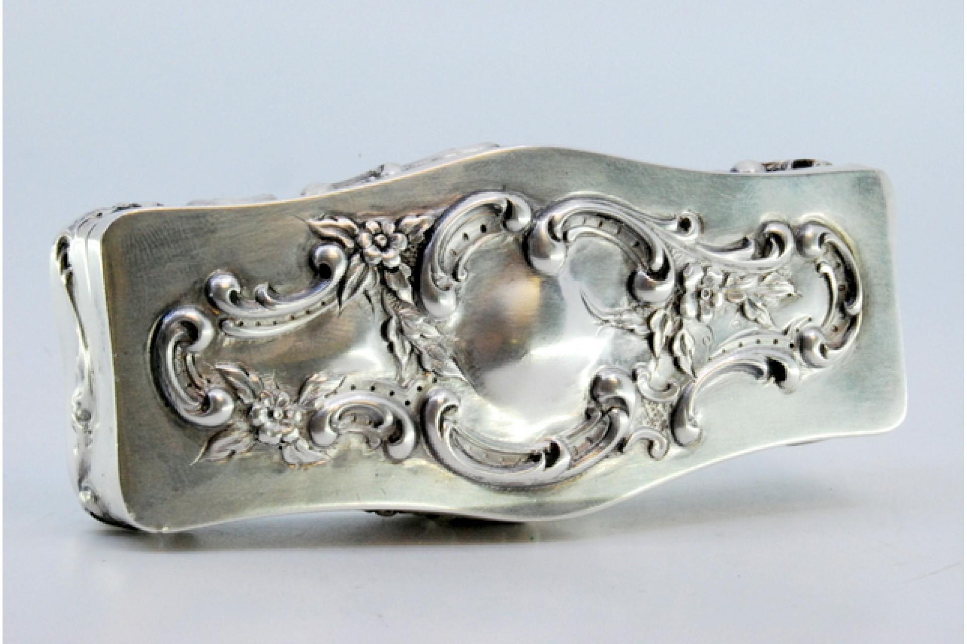 Description : Boîte en argent repoussé avec des motifs floraux et des volutes. Métal : Argent. Origine : Portugais. Marque : Eagle Head. Poids : 98,11 grammes. Dimensions : 11 x 3,5 cm : 11x3,5cm. Contenu : 833/1000. Marque d'essai : Oui, entre 1938