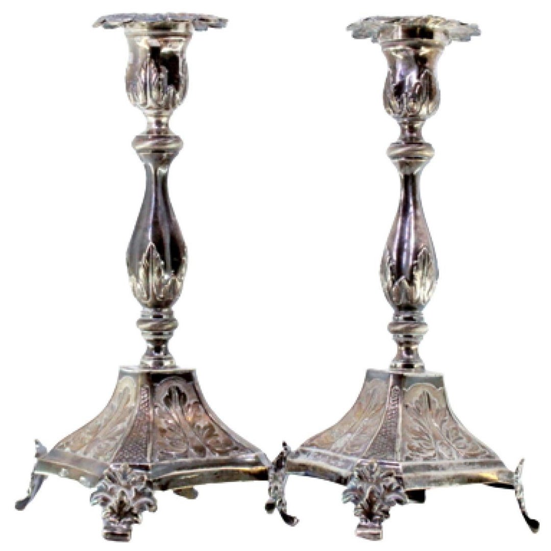 Embossed silver candlesticks with acanthus stems and cut-out feet on squares