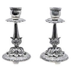 Embossed silver candlesticks with scrolls, florals and circular bases