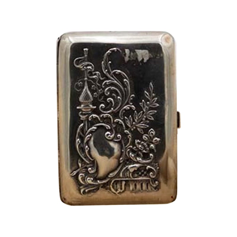 Embossed silver case with Islamic motifs, monogram plate, floral bouquets