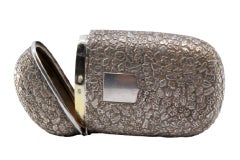 Embossed silver case with oval floral motifs, monogram plate, hinged lid