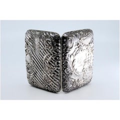 Embossed silver cigarette case with monogram card and hinged lid