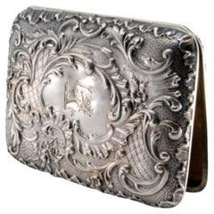 Embossed silver cigarette case with monogram card and hinged lid