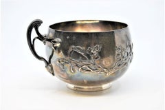 Geprägter Silberbecher mit floralen Motiven und Schleifen auf dem Henkel