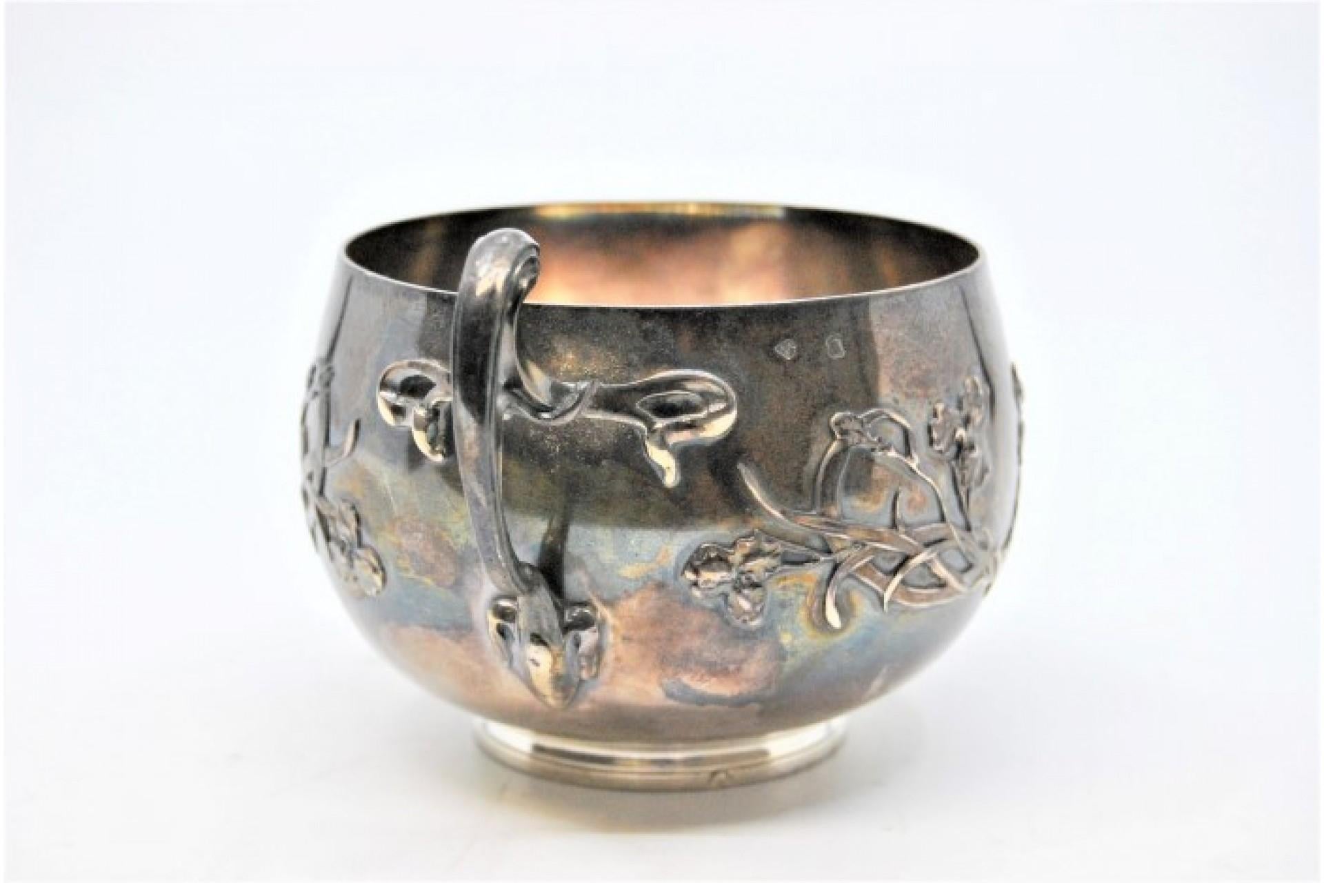 Embossed silver cup with floral motifs and bows on the handle siglo XIX en venta
