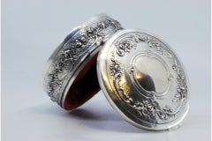 Embossed silver jewelry box with floral motifs and red velvet lining
