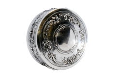 Embossed silver jewelry box with floral motifs and red velvet lining