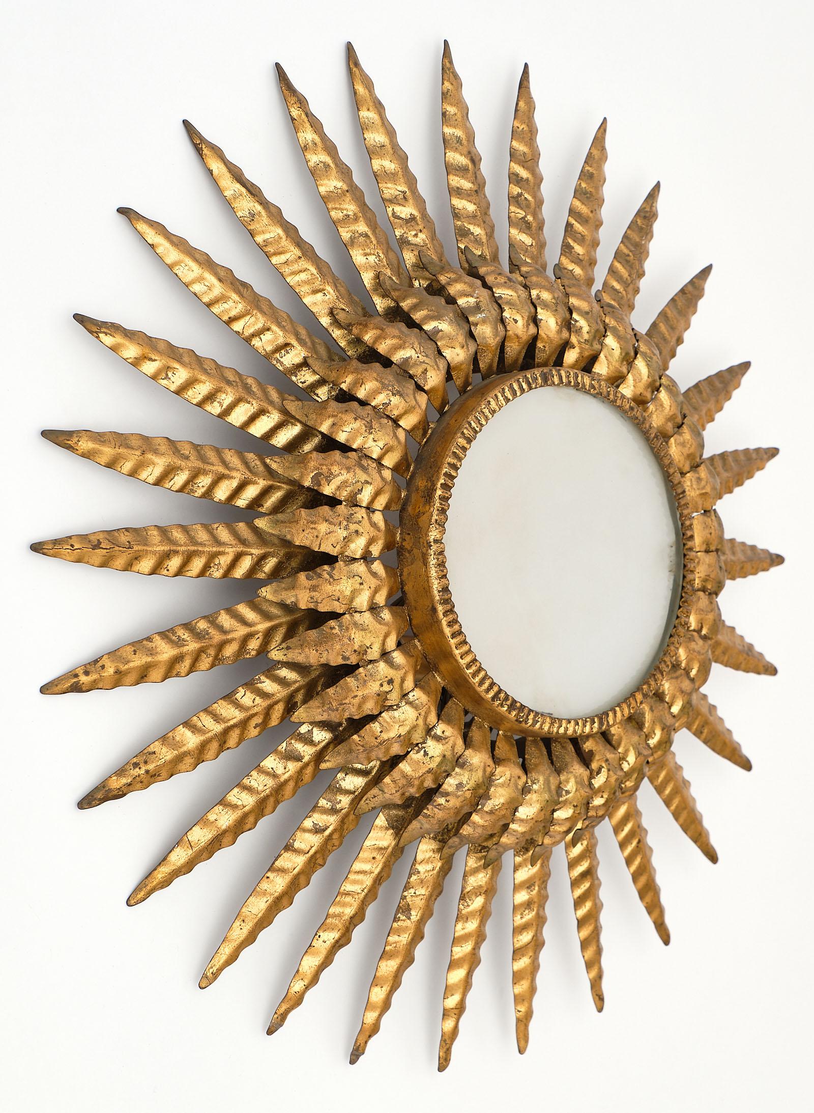 French Art Deco period embossed tole sunburst wall light. This piece is finished with a lustrous gold leaf finish, and has been newly wired to fit US standards.