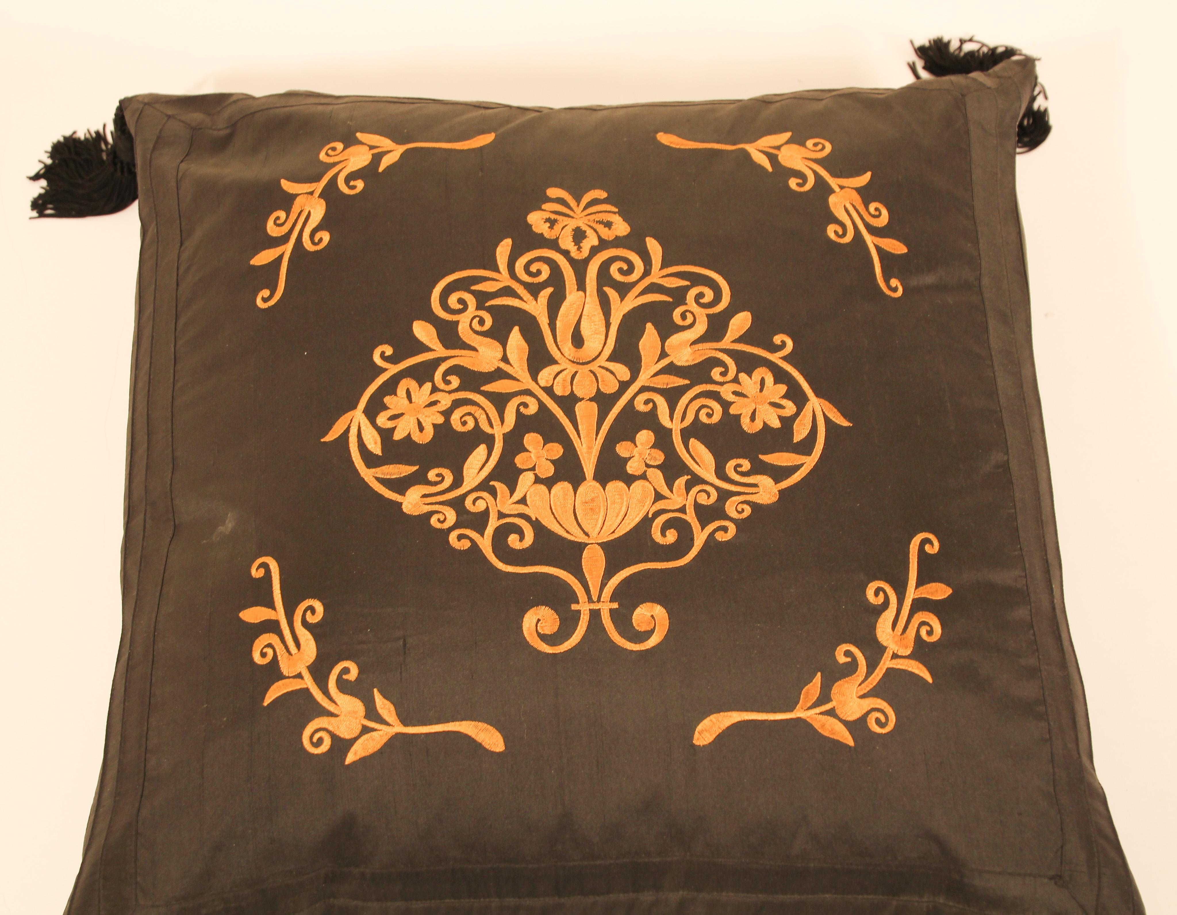 Black silk decorative accent pillow with tassels.
Gold embroidered silk with four large tassels.
Baroque gold floral decor embroidered in front of the pillow.
  