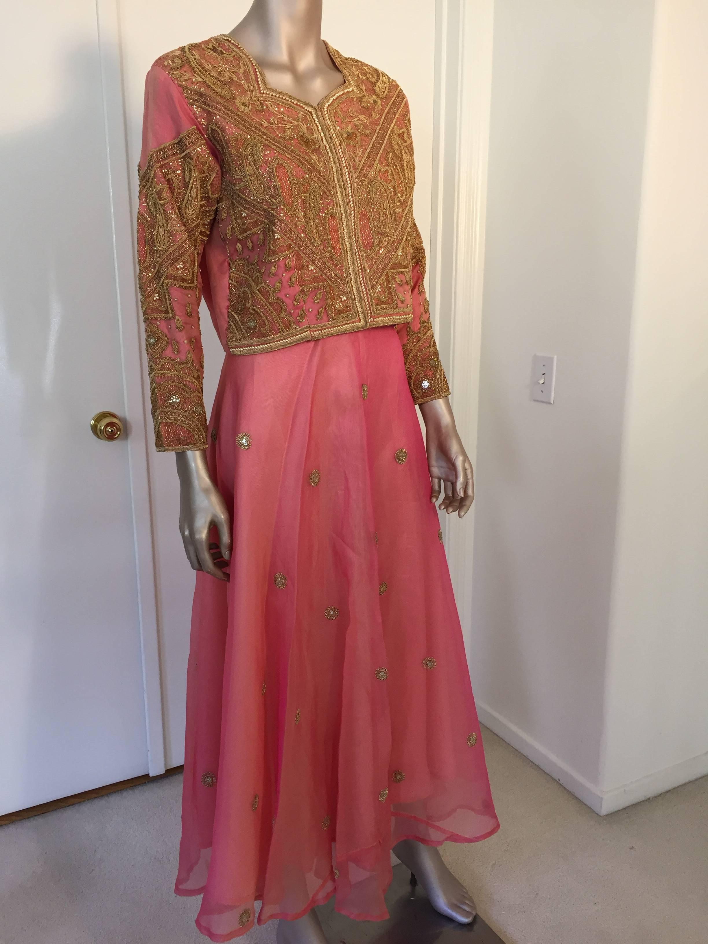 Magnificent 1980s vintage embroidered in gold on pink silk taffeta evening 3 pieces gown, vest, skirt and matching shawl.
The stunning beaded and sequined evening custom made Anglo Raj wedding pink silk taffeta blazer is detailed with gold of micro