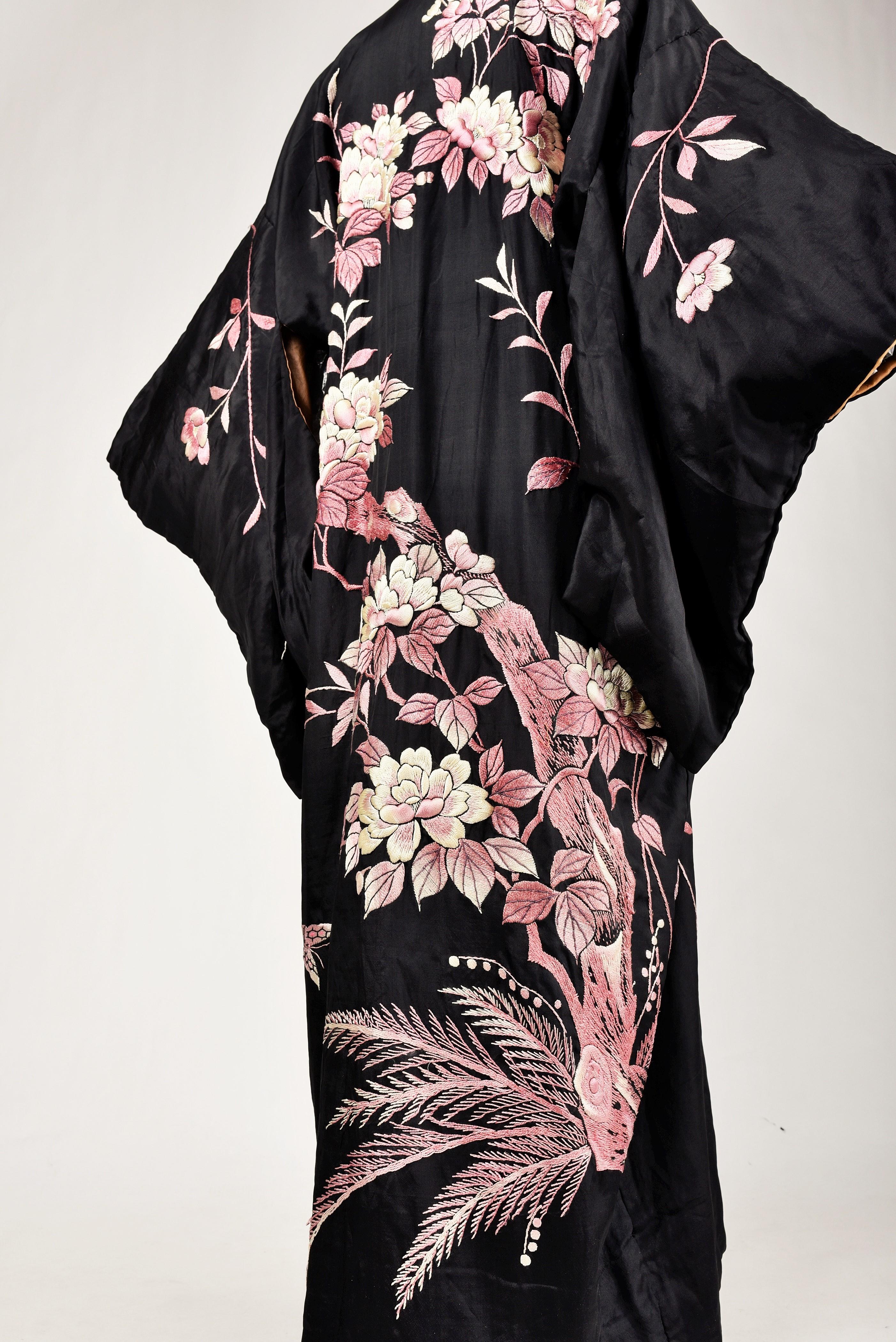 Circa 1920 -1940

France

Black taffeta kimono embroidered with a flowering tree, Japanese work from the 1920s. Beautiful embroidery in relief of mercerized silk in a camaieu of pink, parma and white with a tree of life design full of blooming