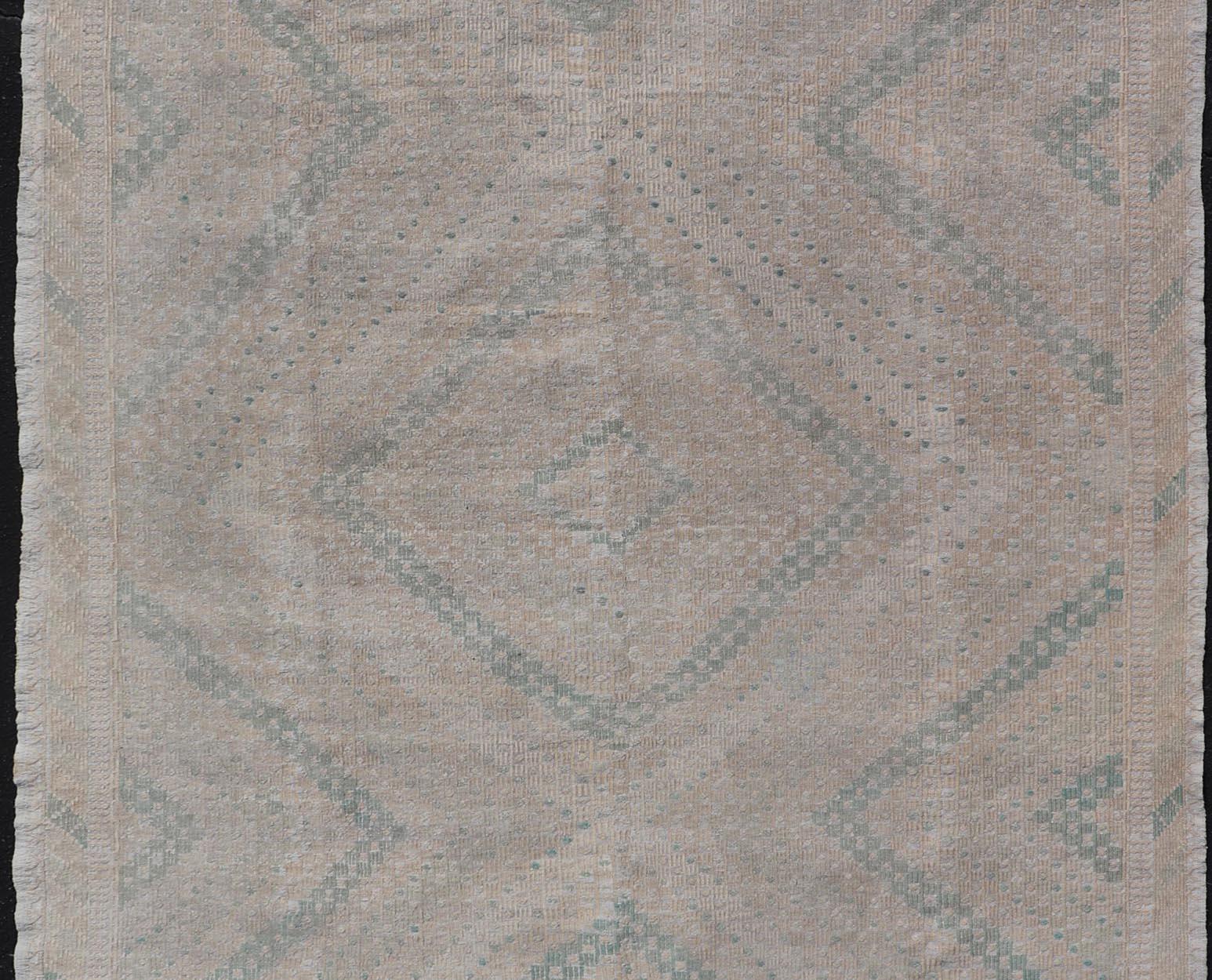 Embroidered vintage Kilim rug from Turkey in shades of tan, light green, light gray, and cream with geometric pattern, Keivan Woven Arts / rug EN-176848, country of origin / type: Turkey / Kilim, circa 1950.

Measures: 6'9 x 10'8.