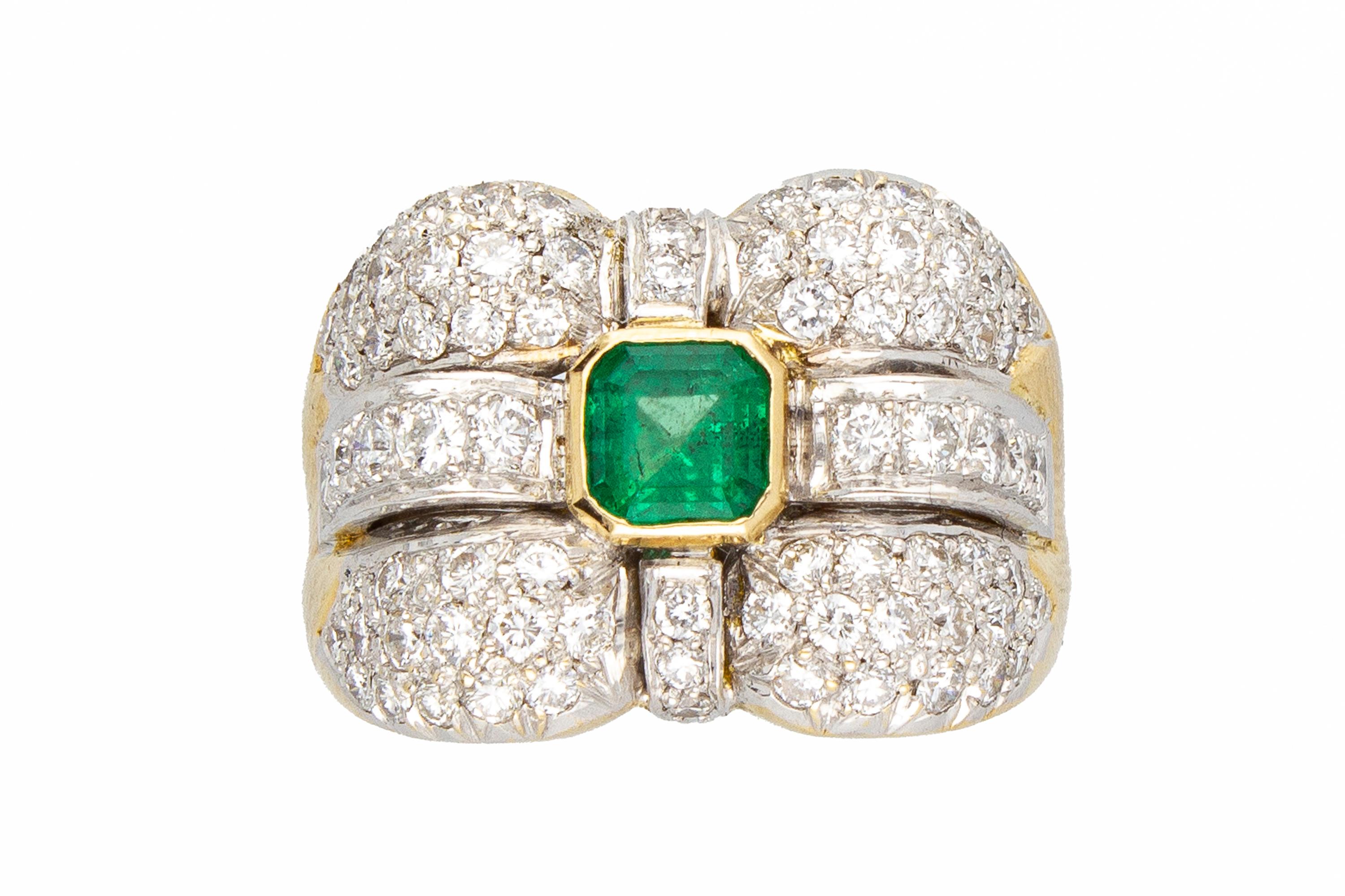 Anello a fascia con smeraldo centrale taglio Assecher da 0,70 carati, circondato da un pavé di diamanti taglio brillante per un totale di 1,60 carati. 
L'anello è in oro giallo 18 Kt, la manifattura è italiana.

Peso totale dei diamanti: 1,60
