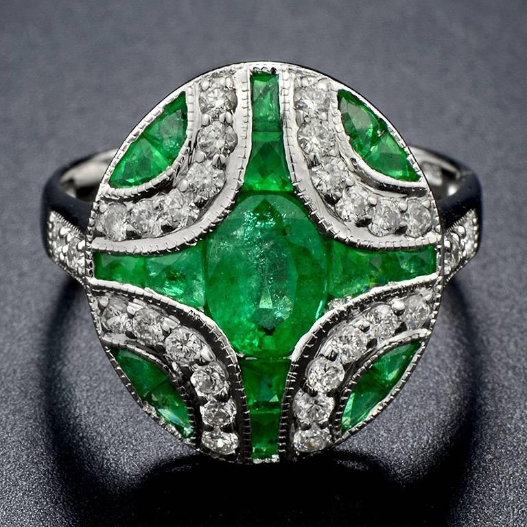 Center Emerald from Zambia weight 1.02 Carat in the center and another 16 pieces 1.50 Carat. forming this special lining design.  Also, there are Brilliant Cut Diamond 24 pieces and 4 pieces on the shoulders total weight 0.42 Carat.

The Ring was