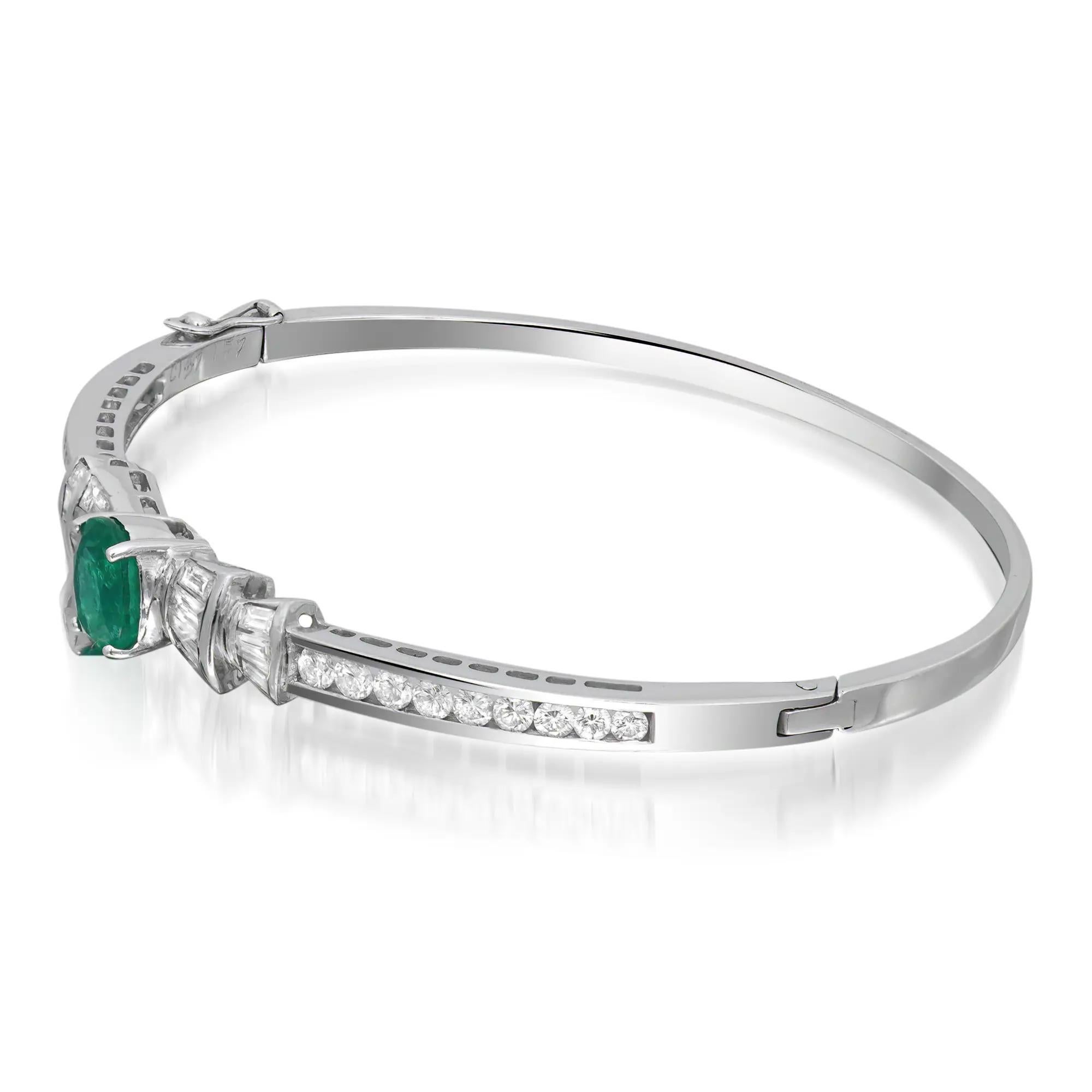 Ce bracelet joliment travaillé présente une émeraude ovale sertie au centre pesant 1,57 carats et des diamants baguettes et ronds incrustés à mi-hauteur du bracelet. Fabriqué en or blanc 18K. Poids total des émeraudes : 1,57 carats. Poids total des