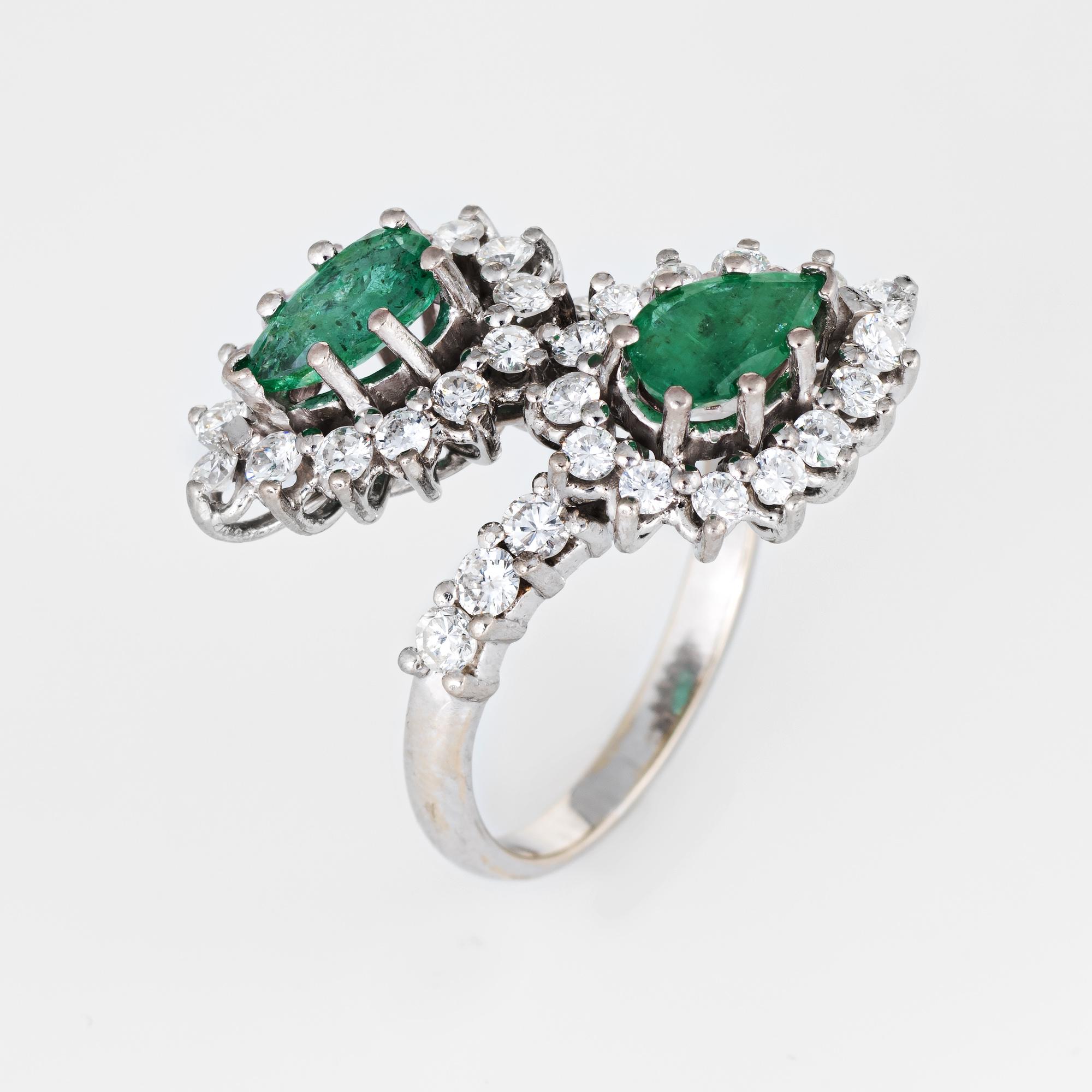 Vintage emerald & diamond bypass ring (circa 1960s to 1970s) crafted in 18 karat white gold. 

Two faceted pear cut emeralds each measure 7mm x 4mm (estimated at 0.50 carats each - 1 carat total estimated weight). The round brilliant cut diamonds