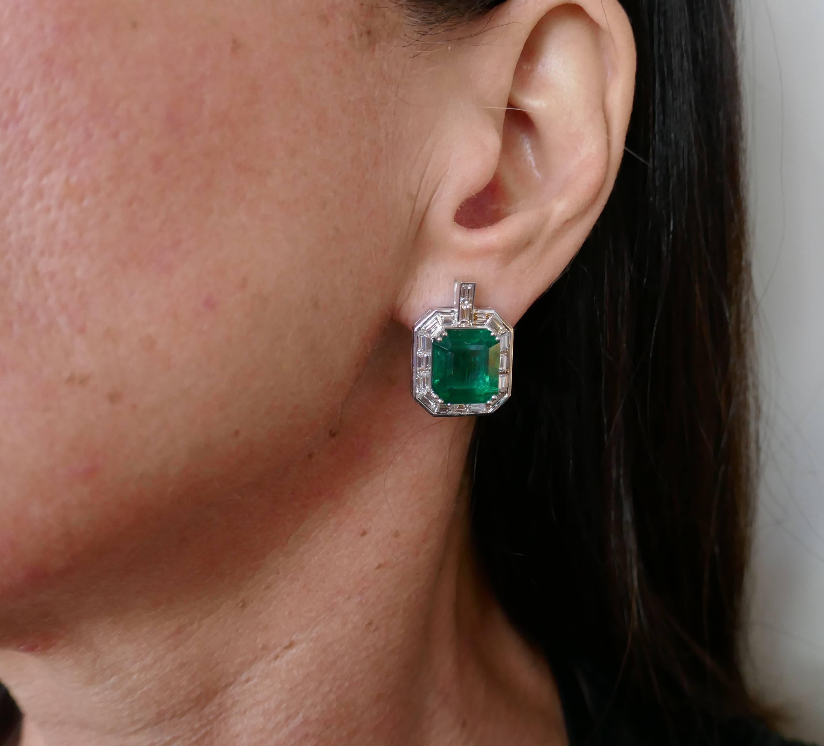 A pair of magnificent earrings featuring two Zambian emeralds. Classy, timeless and wearable, the earrings are a great addition to your jewelry collection.  
The emeralds are framed with a row of sleek baguette cut diamonds and set in 18 karat white