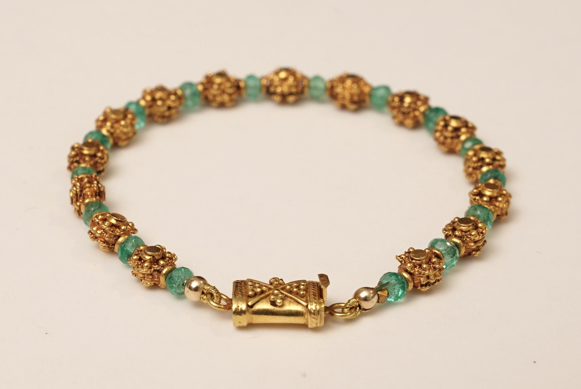 A beaded bracelet of faceted Columbian emeralds with 22K gold beads.  The beads have a subtle flower motif with fine granulation work, as does the push clasp.  Wear alone or it plays well with others.  By Deborah Lockhart Phillips

The fine jewelry