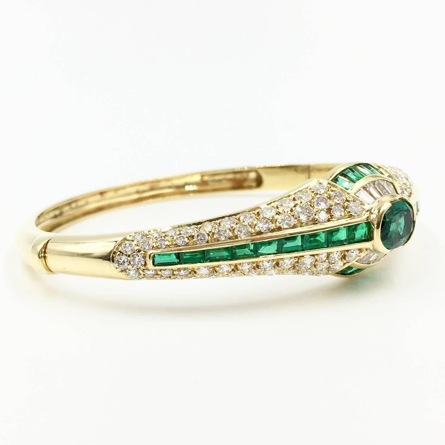A beautiful emerald and diamond Art Deco inspired bangle bracelet made with exceptional quality stones. Made in 18K yellow gold with incredible craftsmanship. The emerald color is a very rich and lively green. Diamonds are of high quality,